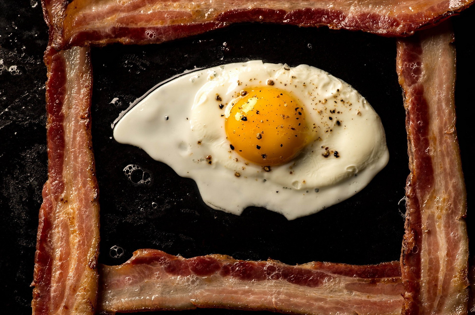 Fried egg in a frame of bacon HD Wallpaper