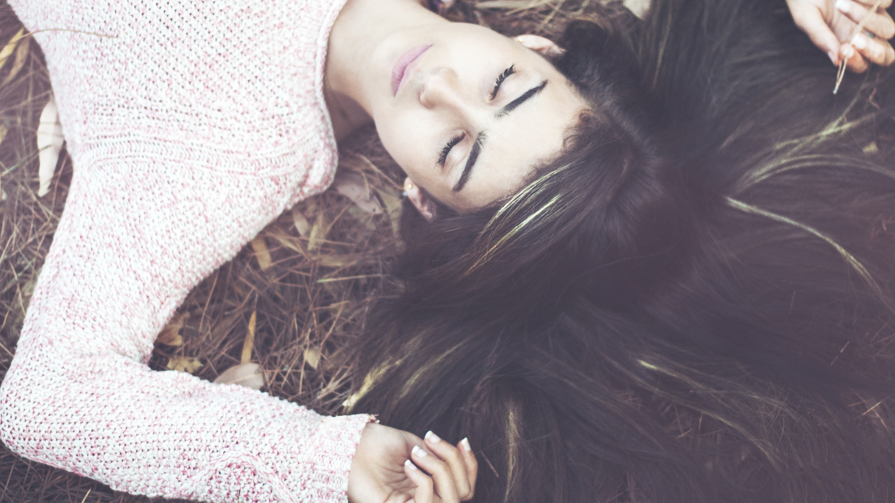 Woman lying on the ground with eyes closed HD Wallpaper