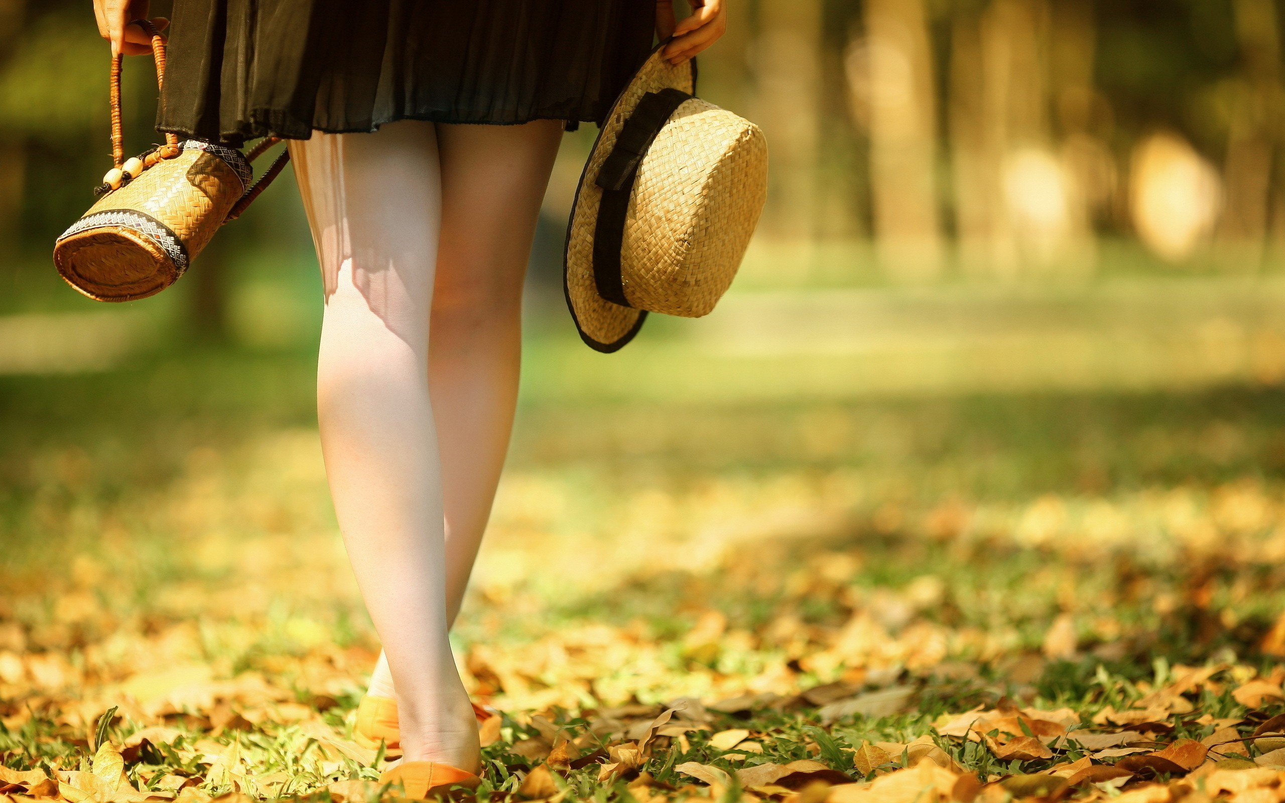 Woman in skirt holding a hat and bag outdoors HD Wallpaper