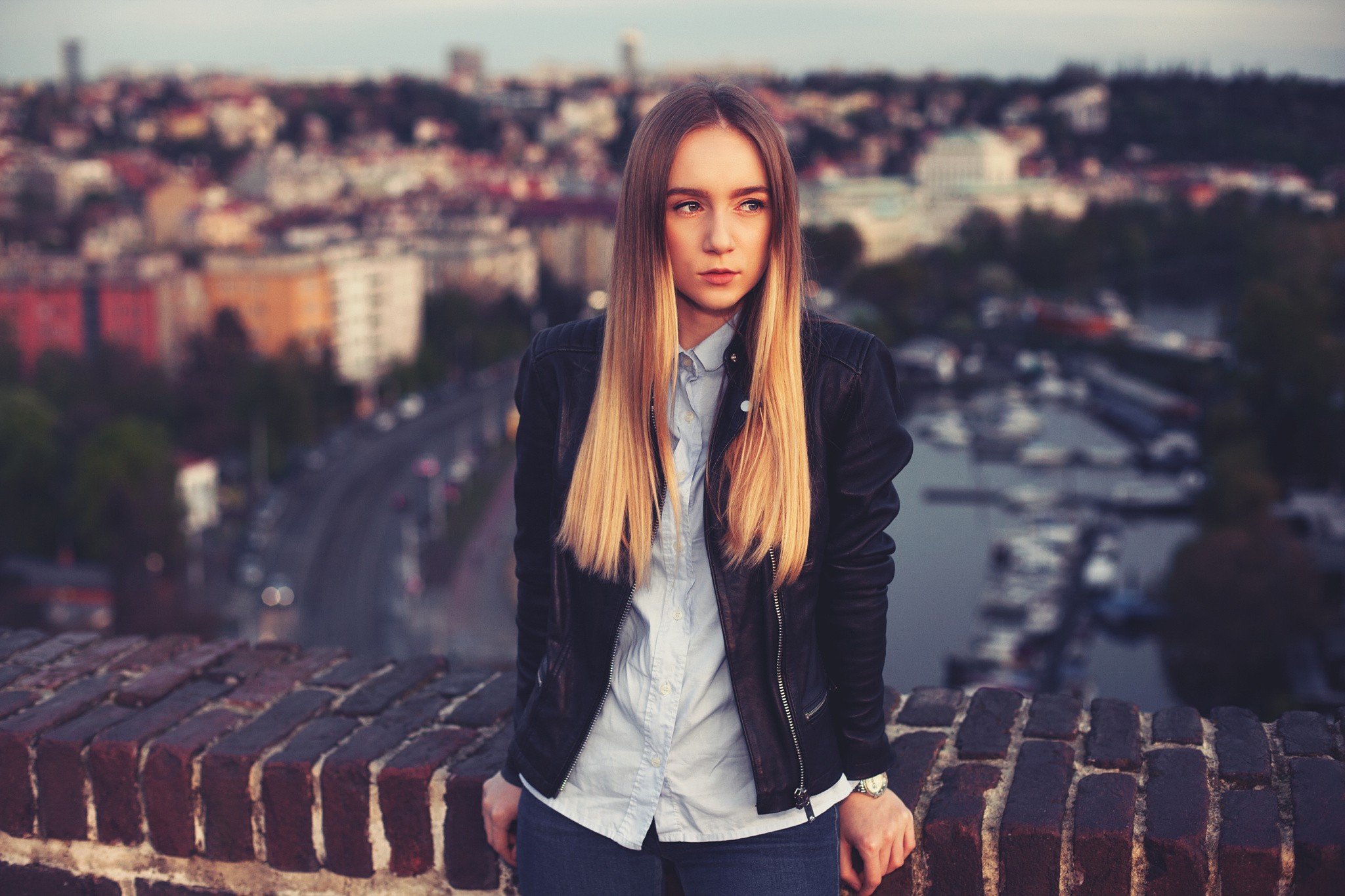 Woman in leather jacket looking away over city HD Wallpaper