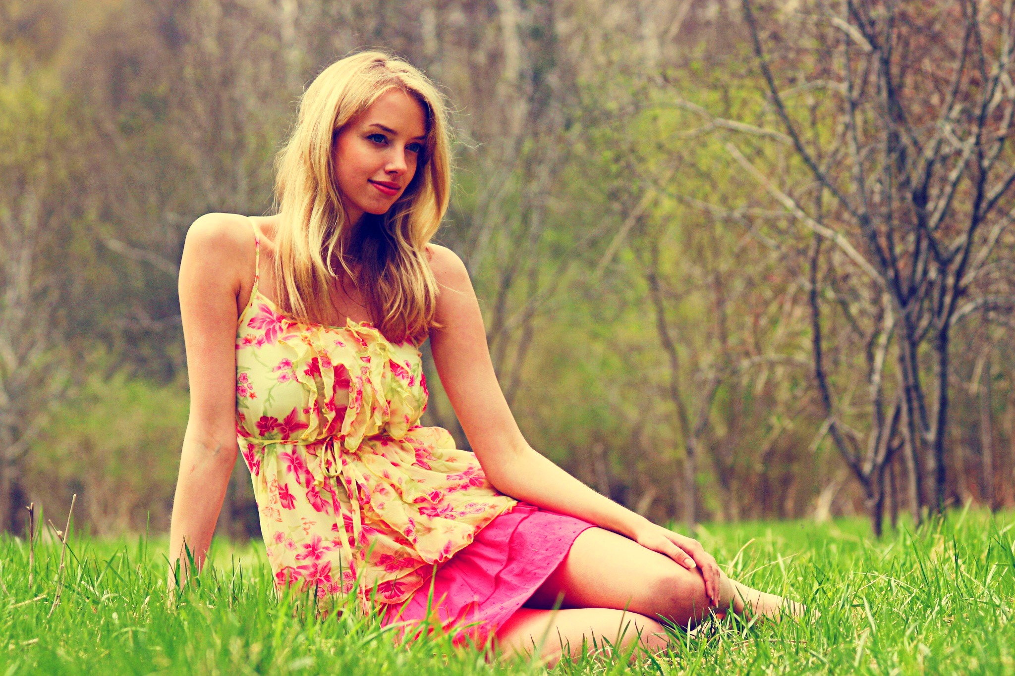 Woman in a floral dress sitting in a grassy field HD Wallpaper