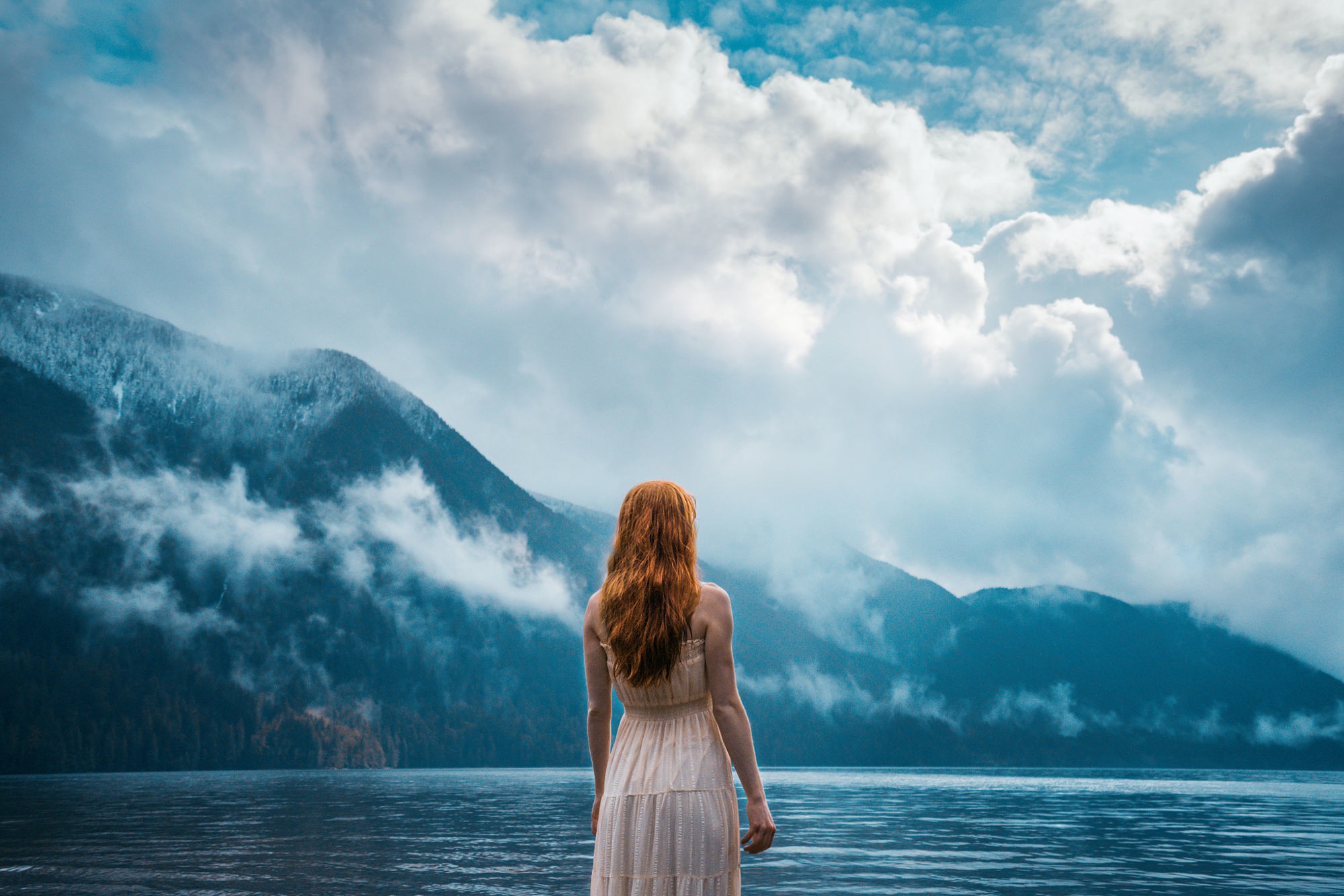 Woman in dress by a lake with mountains and clouds HD Wallpaper
