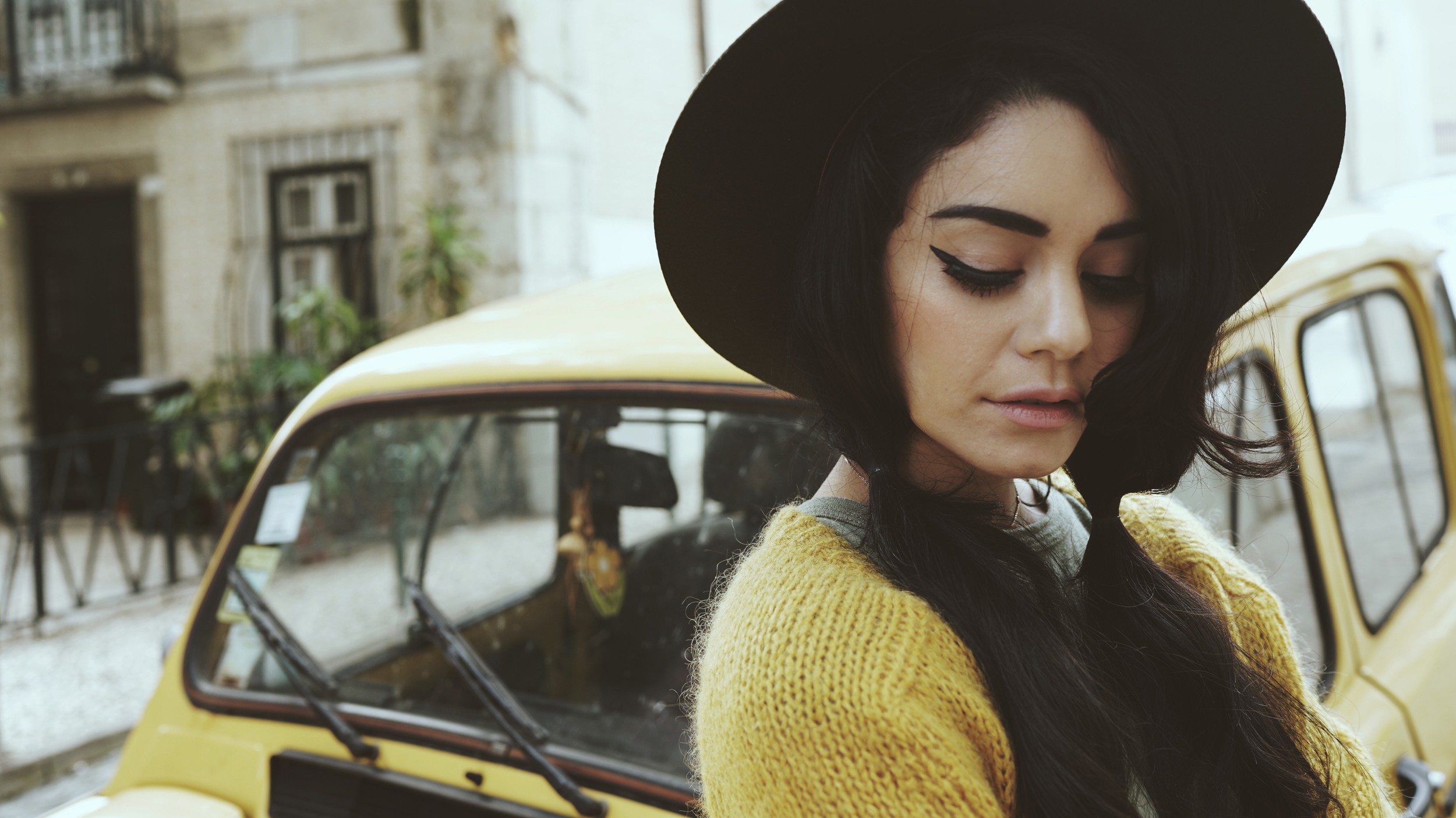 Vanessa Hudgens poses near a yellow car HD Wallpaper