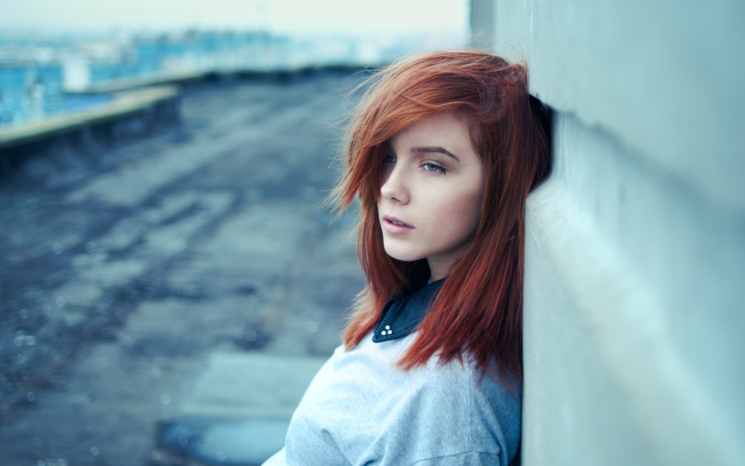 Redhead woman leaning against a wall on a rooftop HD Wallpaper