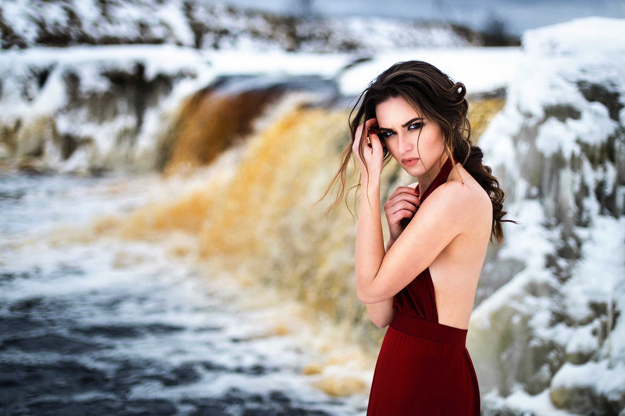 Woman in red dress by waterfall in winter HD Wallpaper