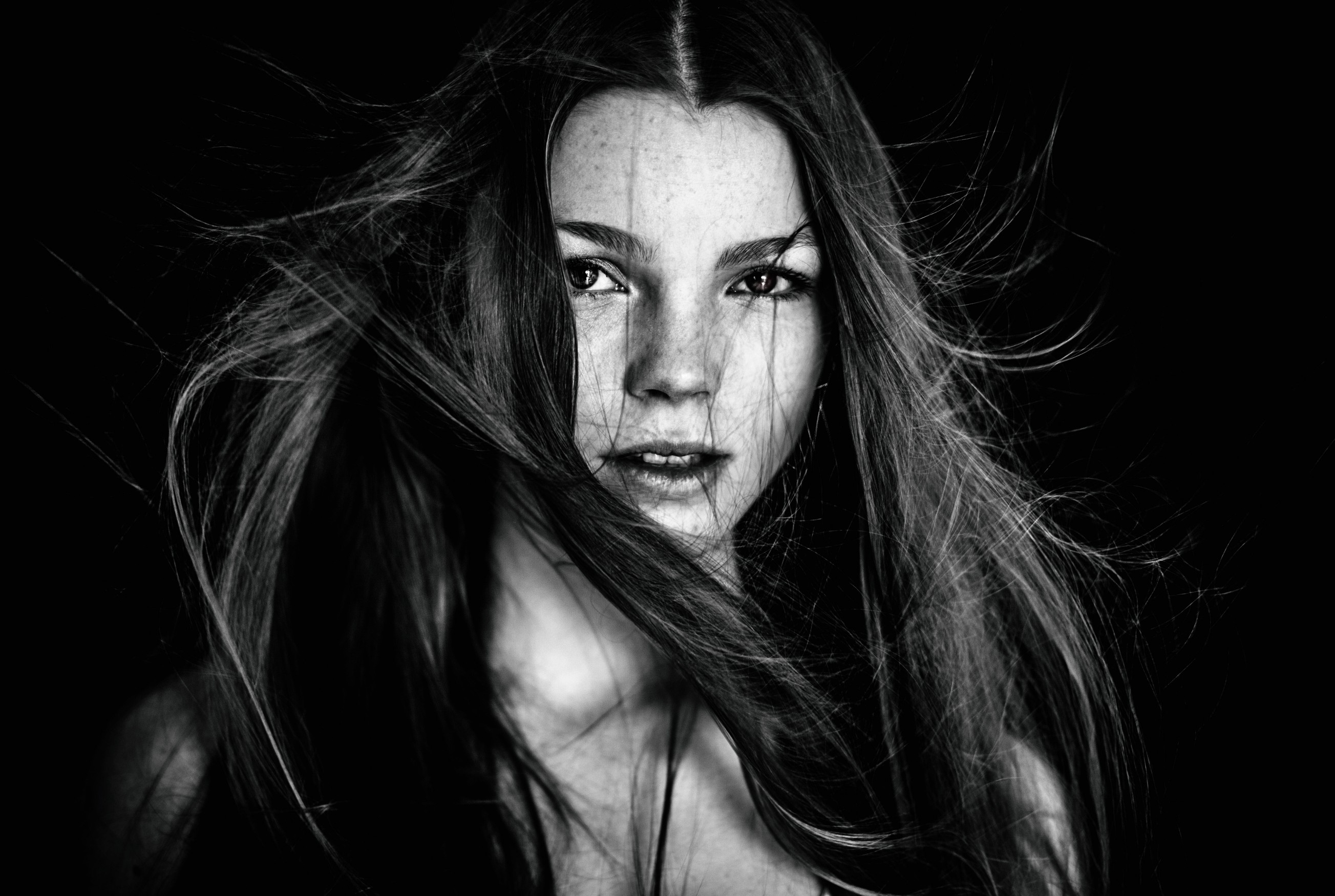 Monochrome portrait of a woman with windblown hair HD Wallpaper