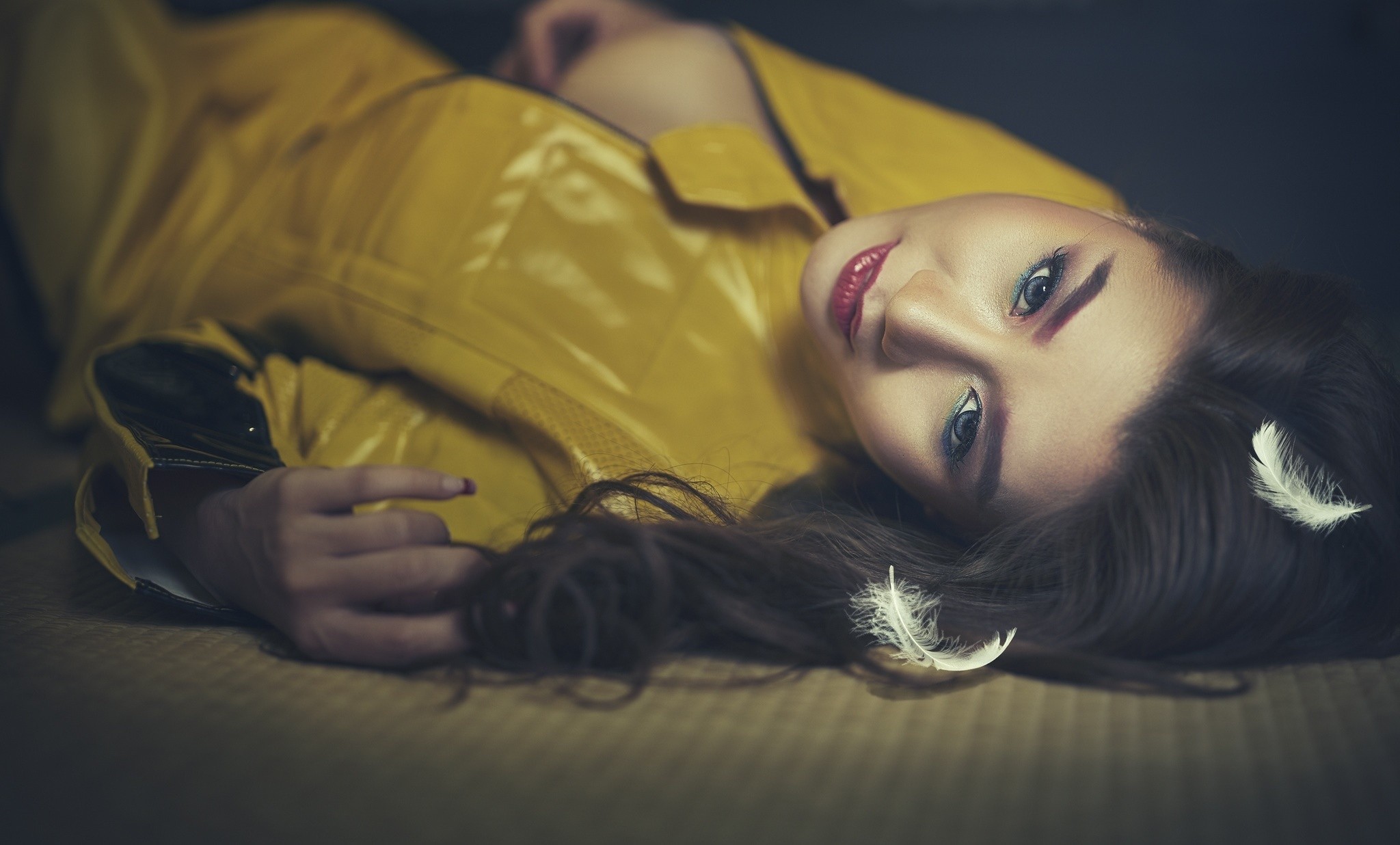 Woman in yellow coat with feathers in hair HD Wallpaper