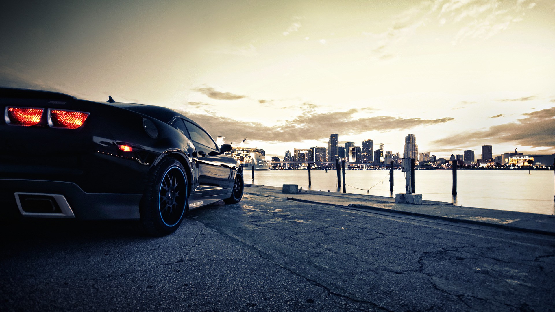 Black Sports Car by the Water with City Skyline HD Wallpaper