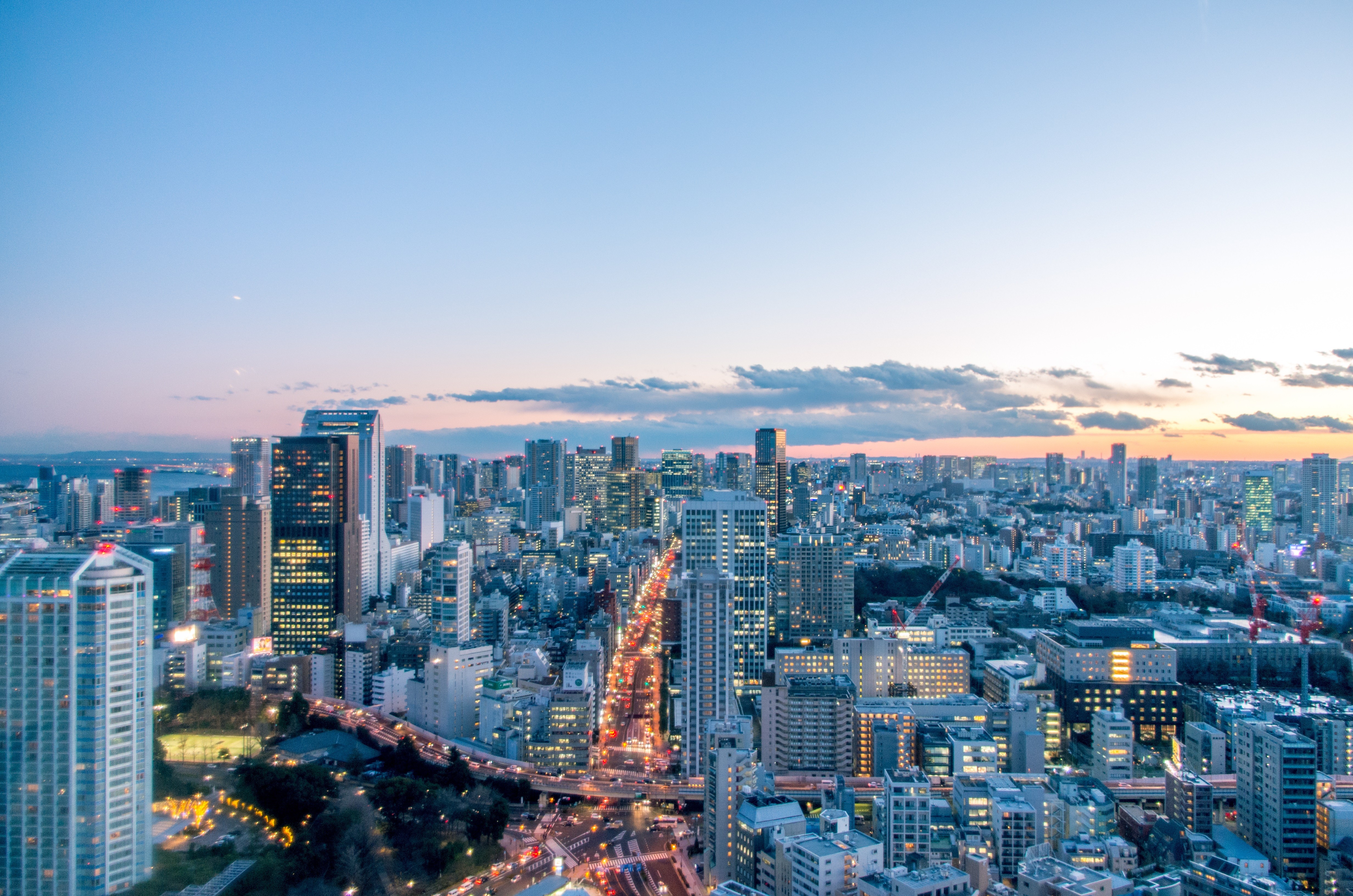 Tokyo cityscape at dusk with illuminated buildings and roads HD Wallpaper