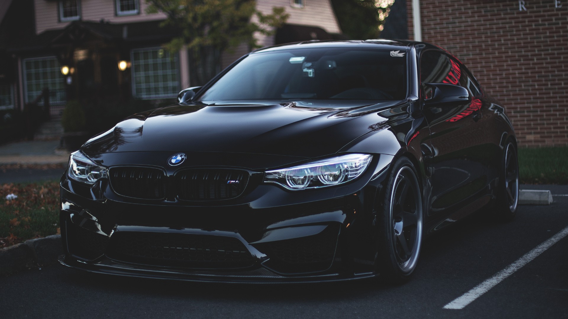 Black BMW M4 parked in a parking lot HD Wallpaper
