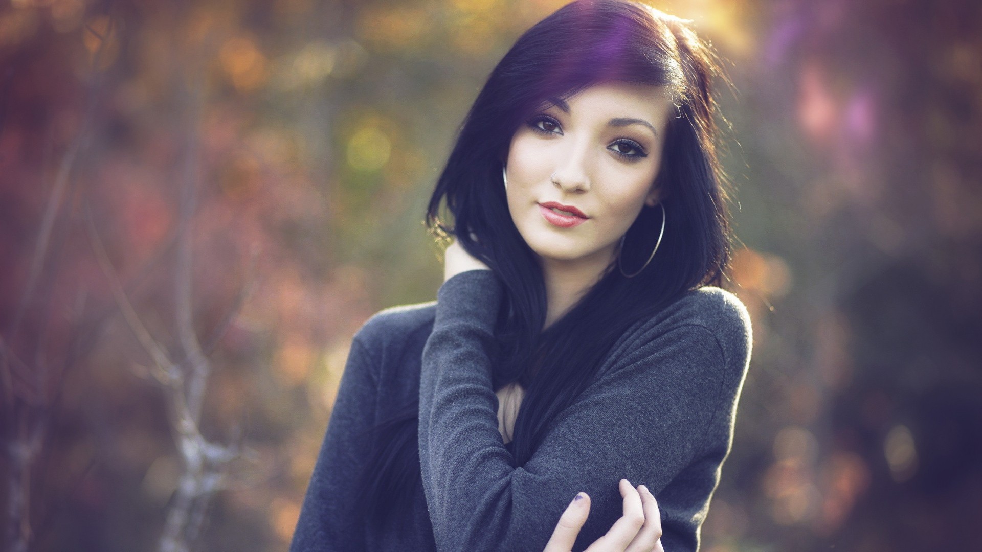 Woman with black hair and hoop earrings in forest HD Wallpaper