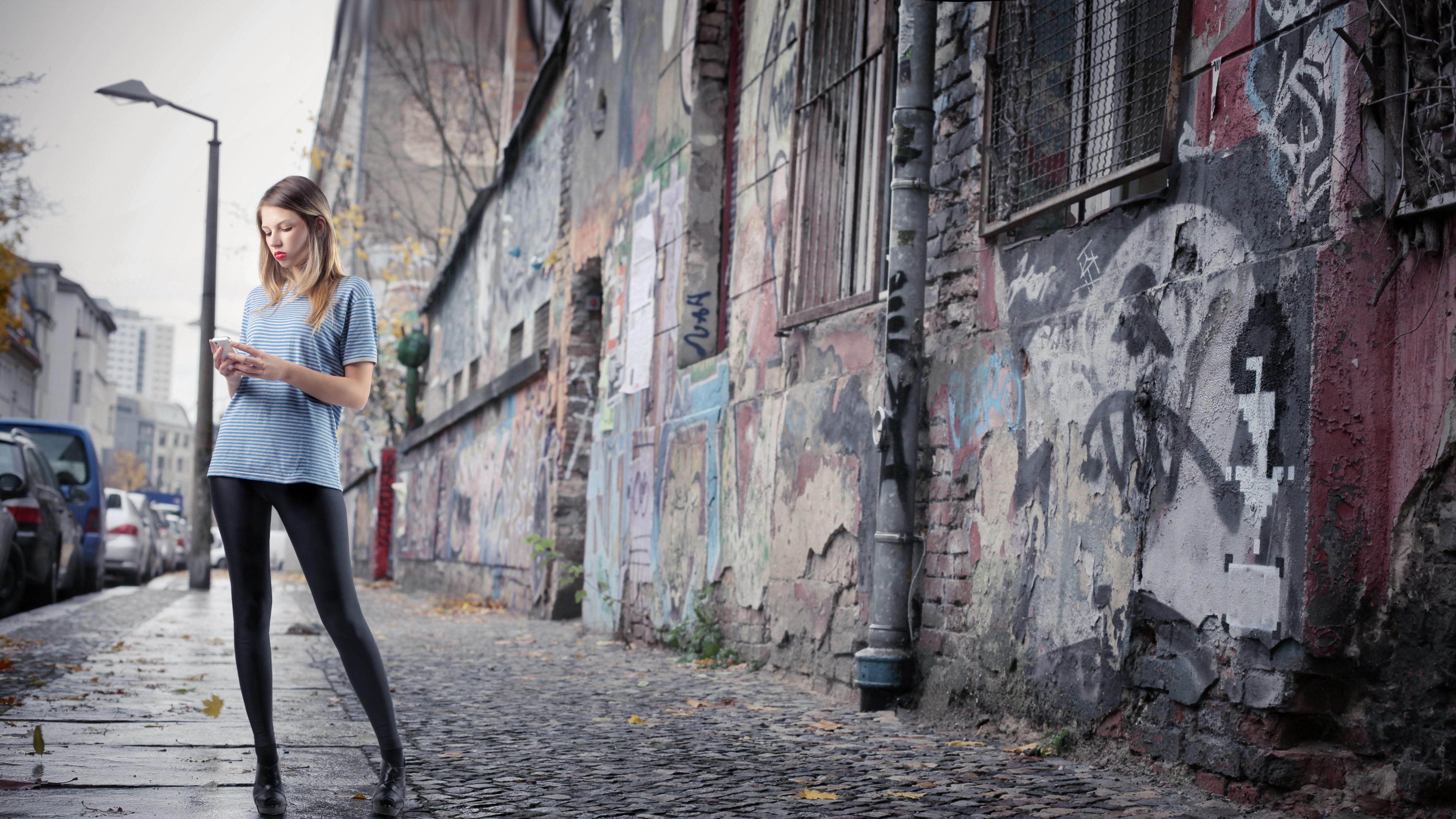 Woman in leggings and blue shirt on a street HD Wallpaper