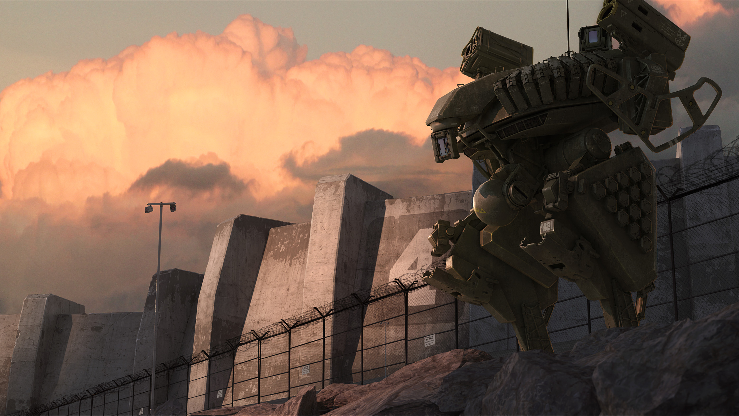 Military mech stands near a concrete wall at sunset HD Wallpaper