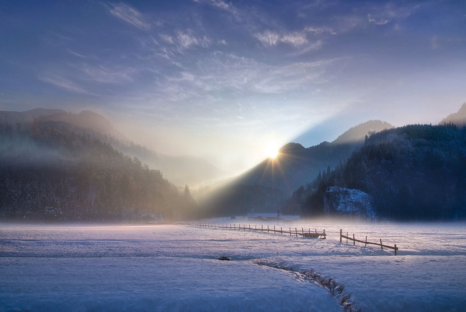 Winter sunset over snowy mountains with sun rays and mist HD Wallpaper