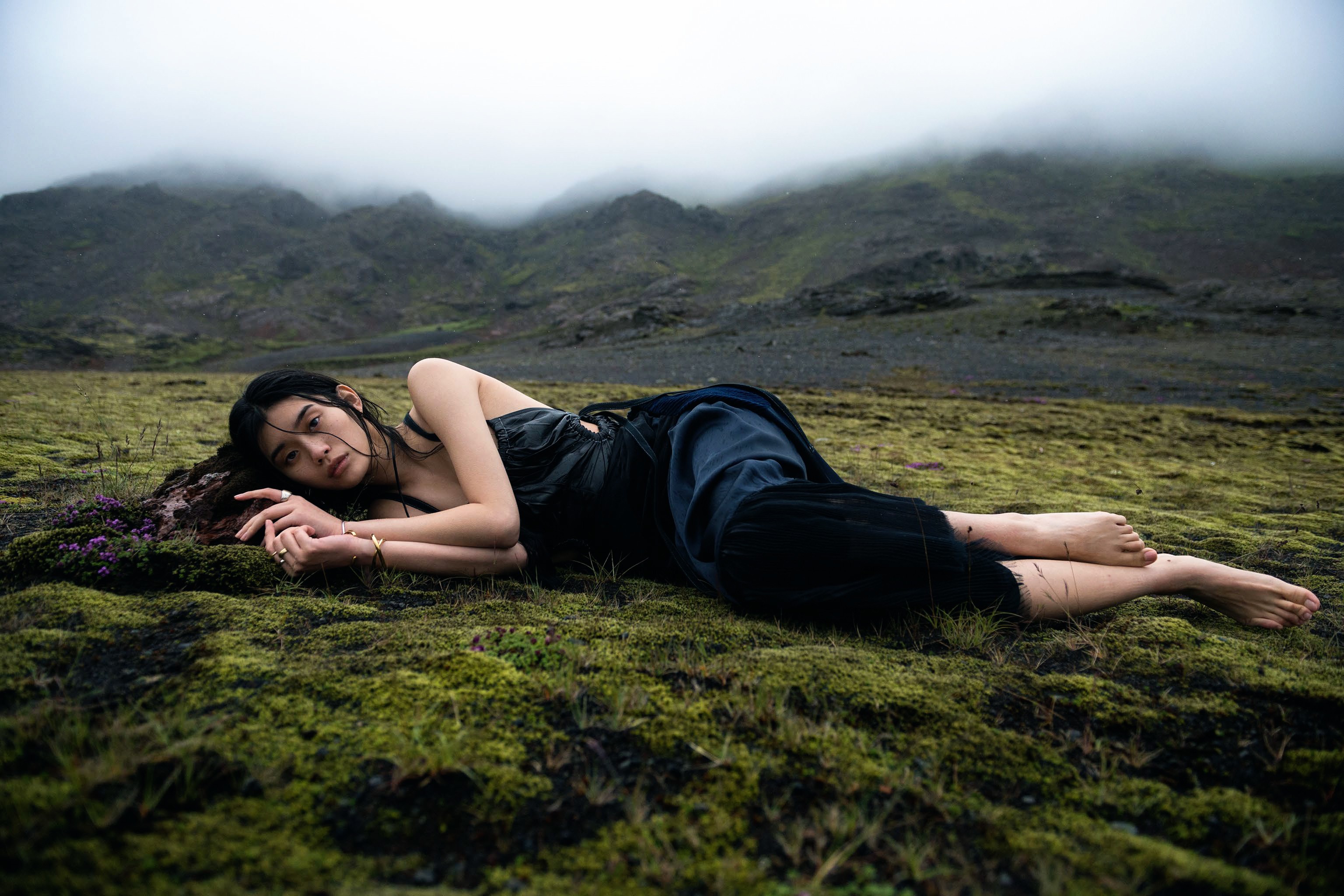 Ming Xi lying on mossy ground in Iceland HD Wallpaper