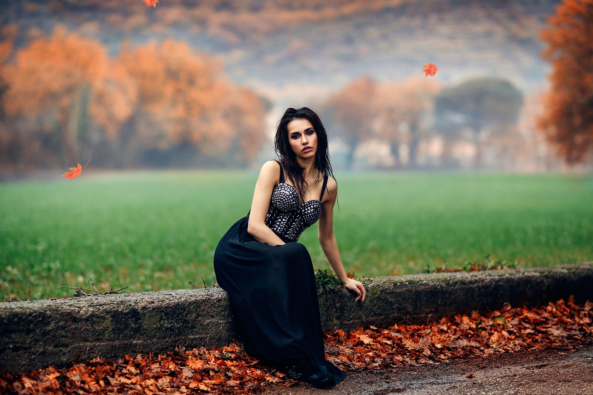 Woman in a black dress sitting outdoors in autumn HD Wallpaper
