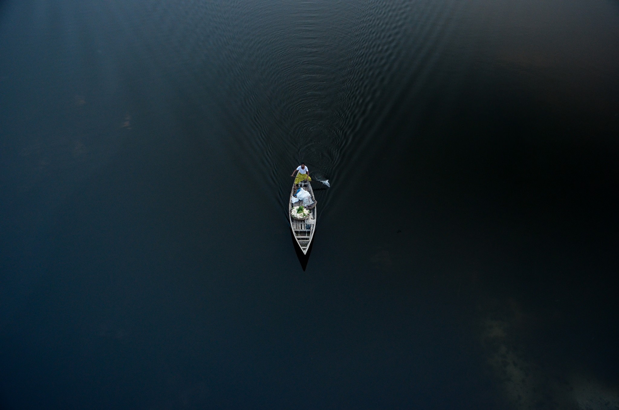 Two people in a boat on dark water HD Wallpaper