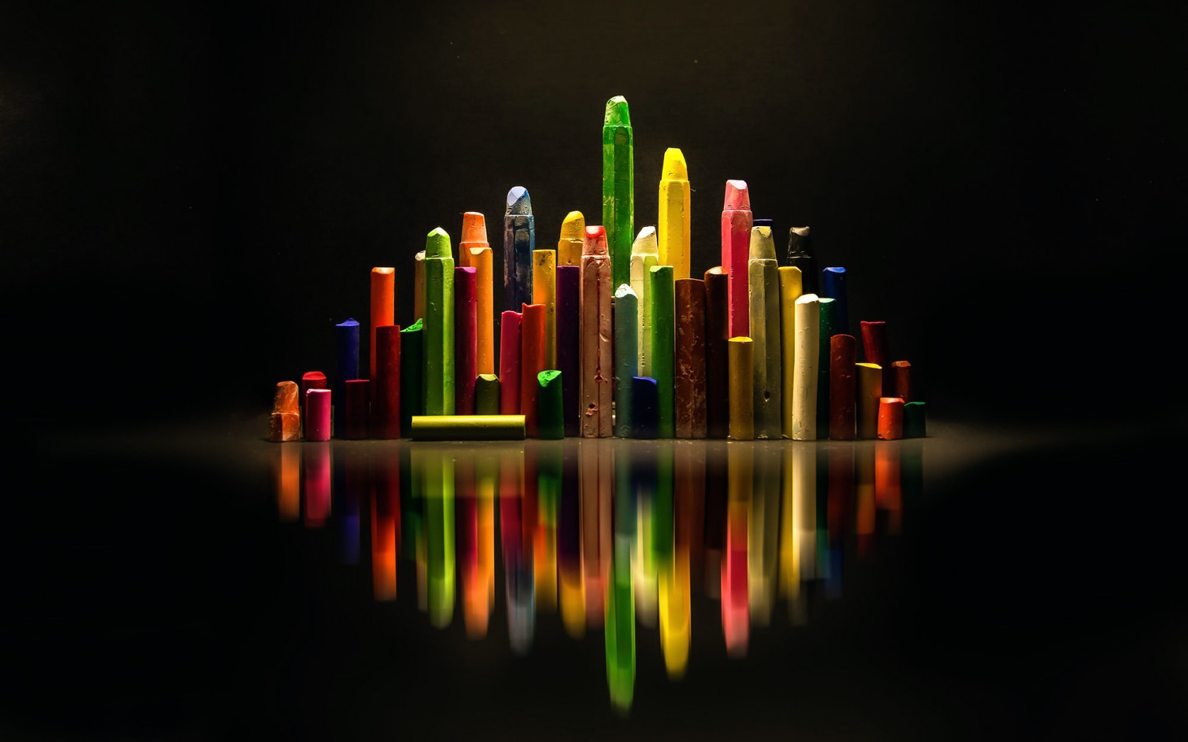 Colorful crayons arranged like a city skyline with reflections HD Wallpaper