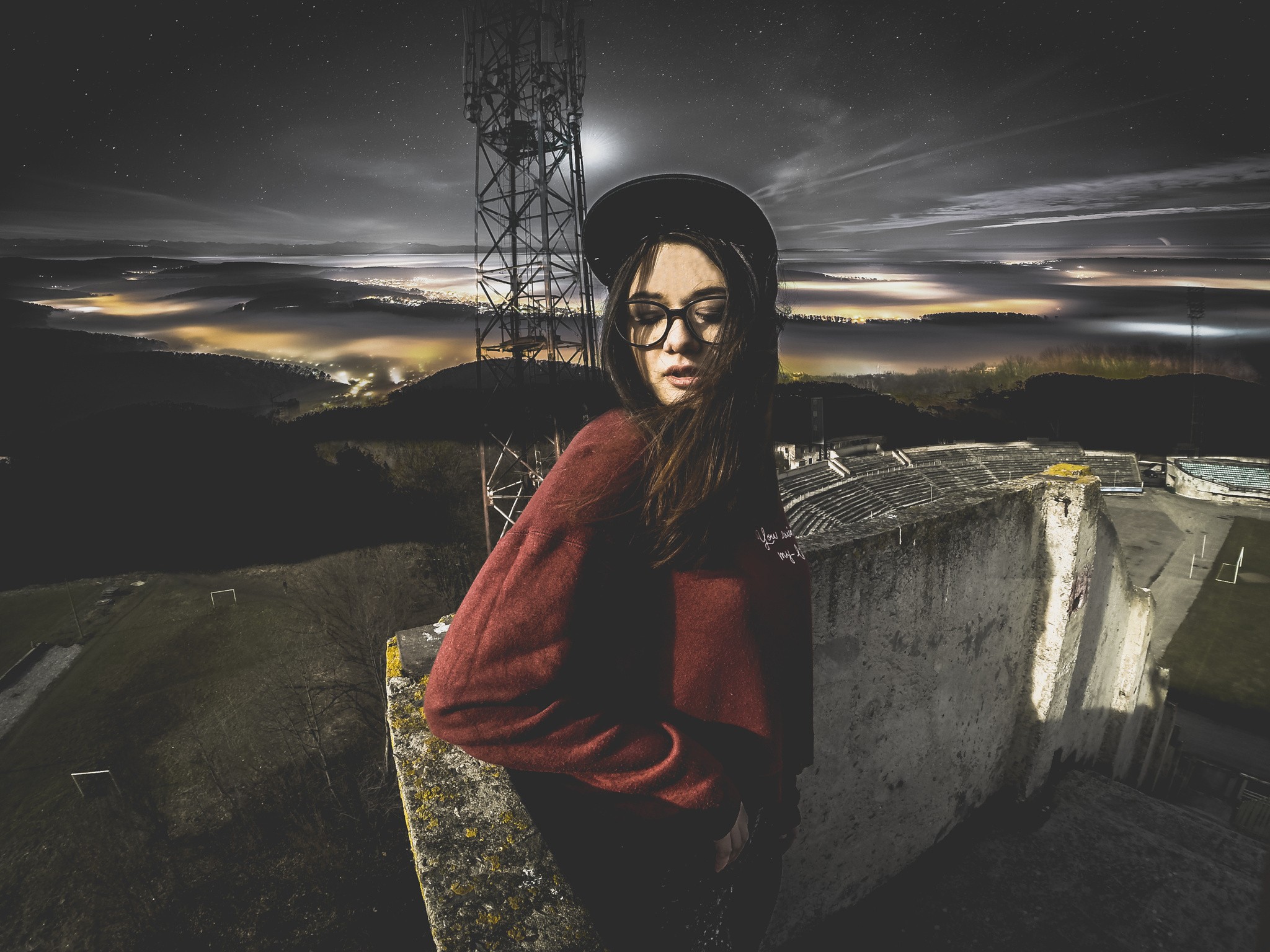 Woman with glasses near a tower at night HD Wallpaper