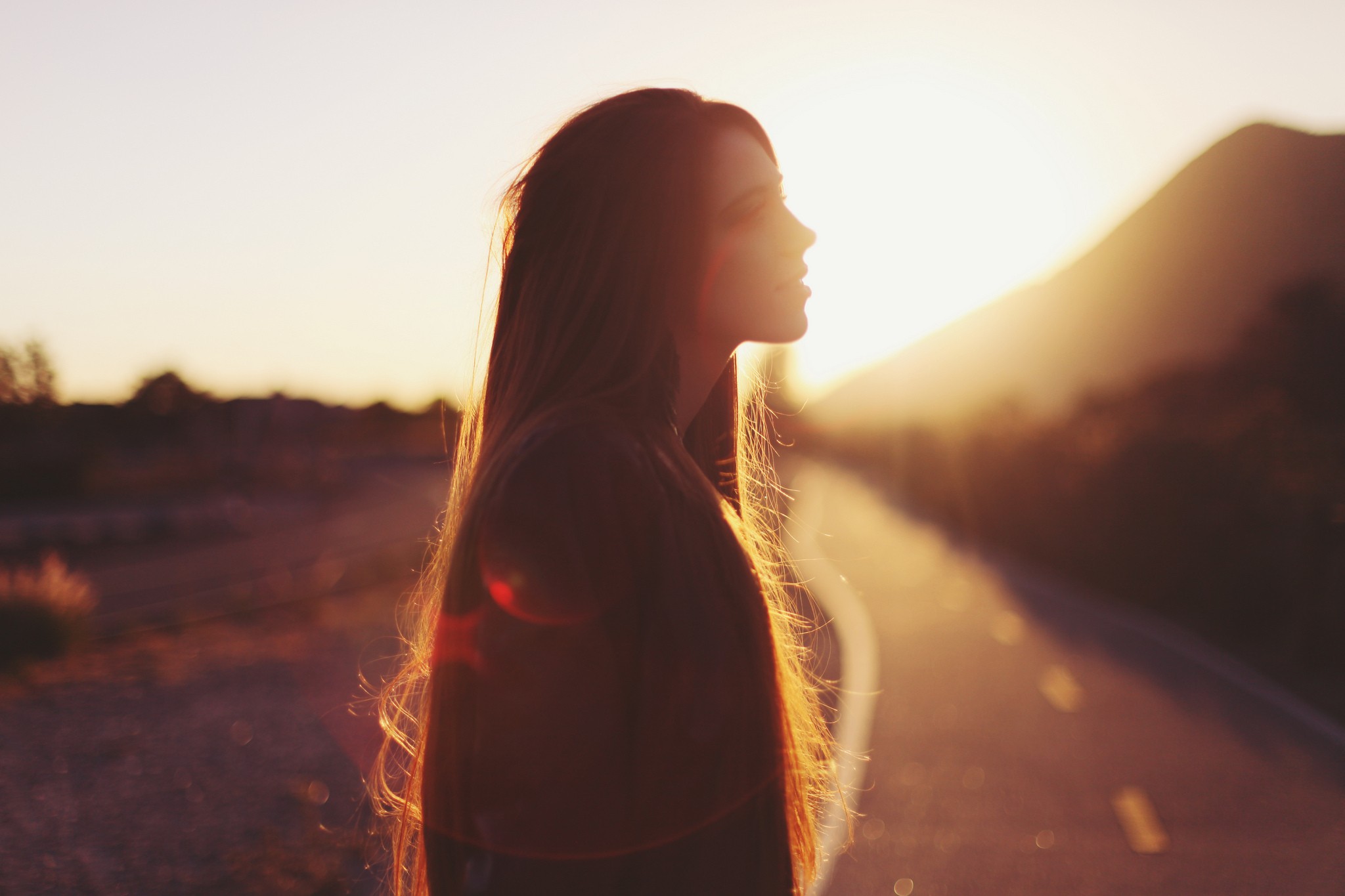 Woman in profile against the sunset on a road HD Wallpaper