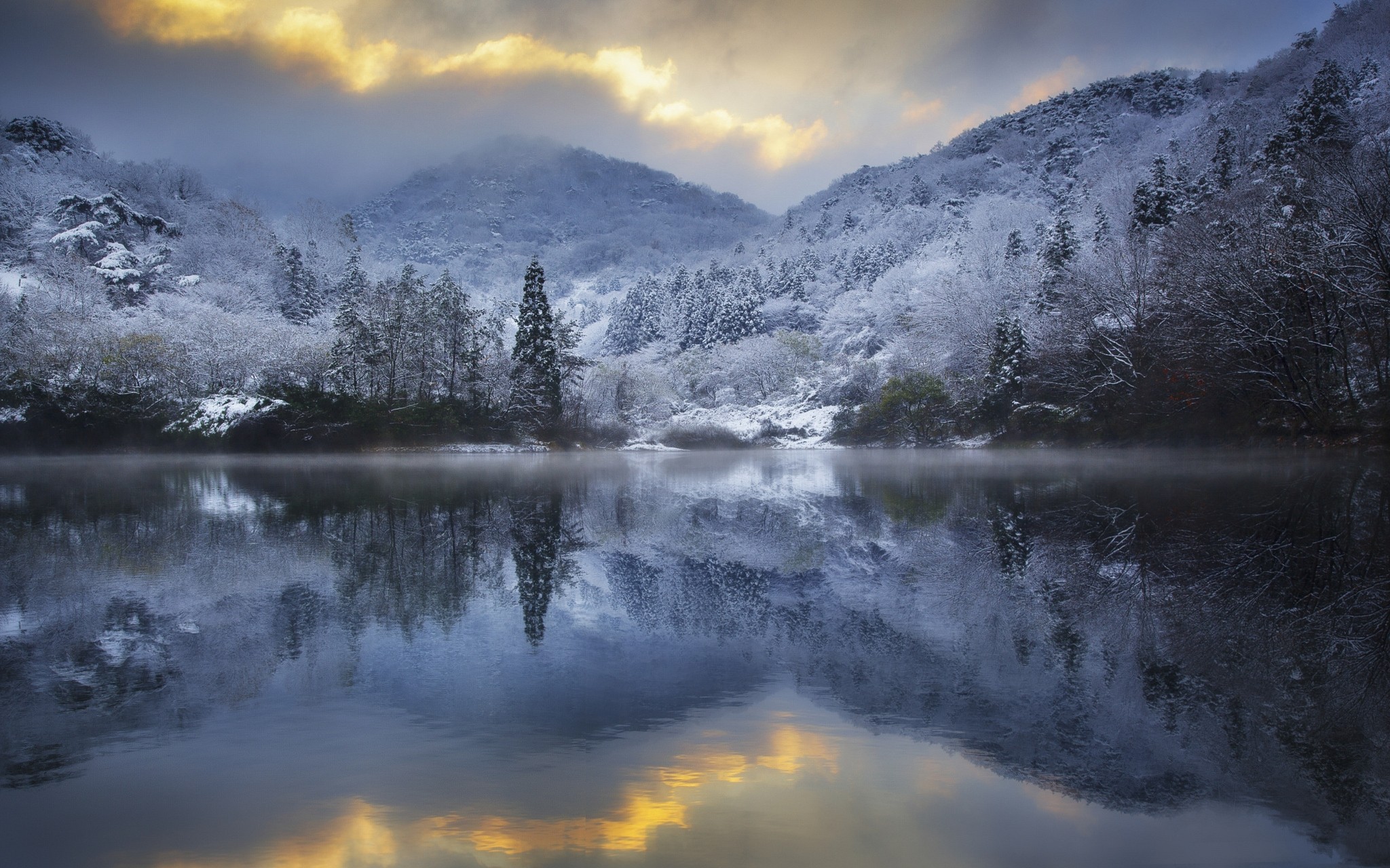 Snowy hills reflected in a misty lake at sunset HD Wallpaper