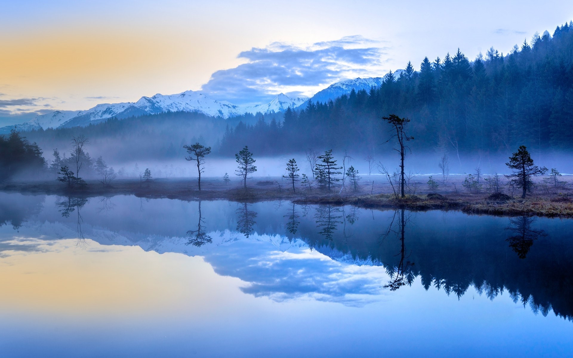 Misty lake with reflections of mountains and forest HD Wallpaper