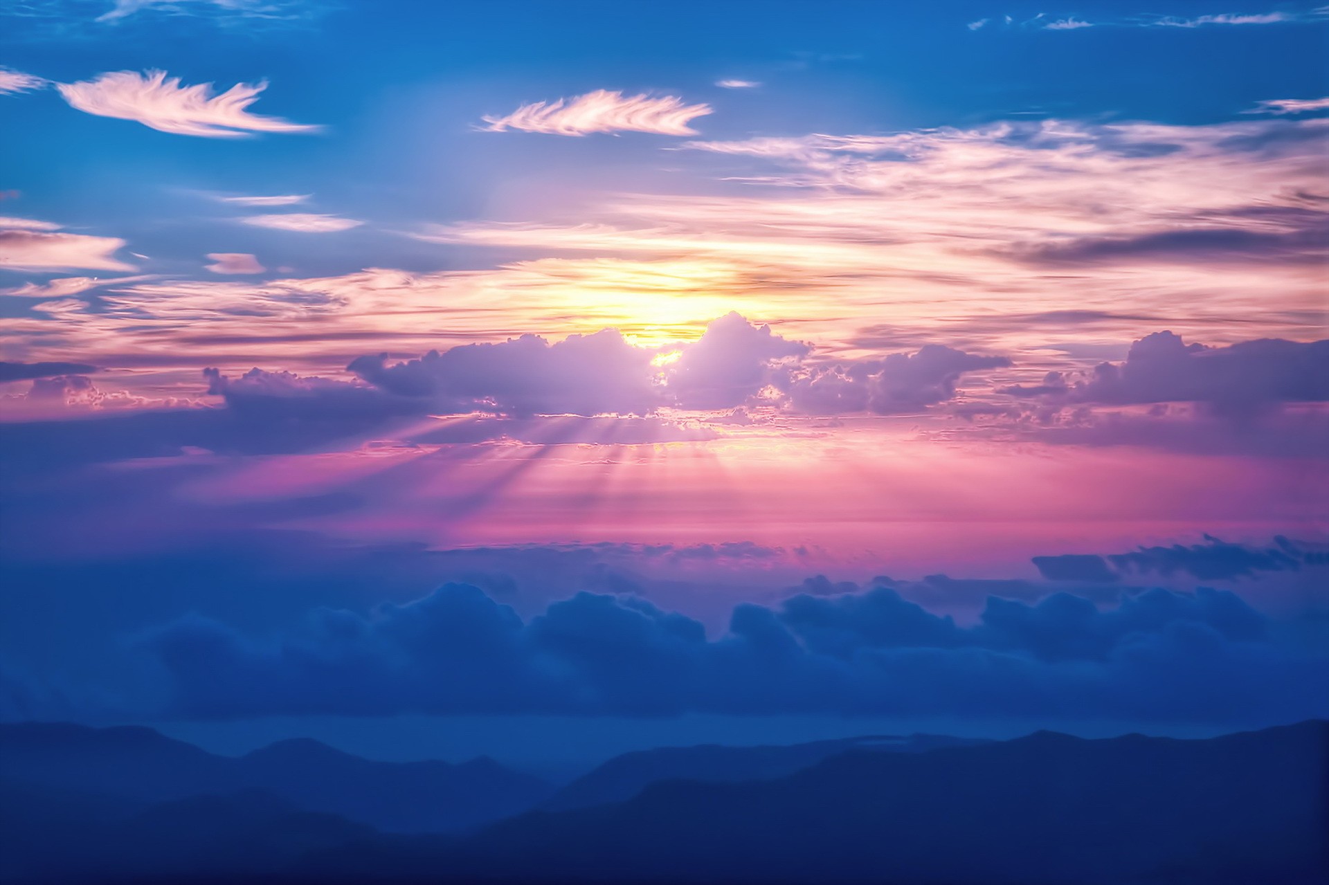 Sunlight beams through colorful clouds over mountains HD Wallpaper
