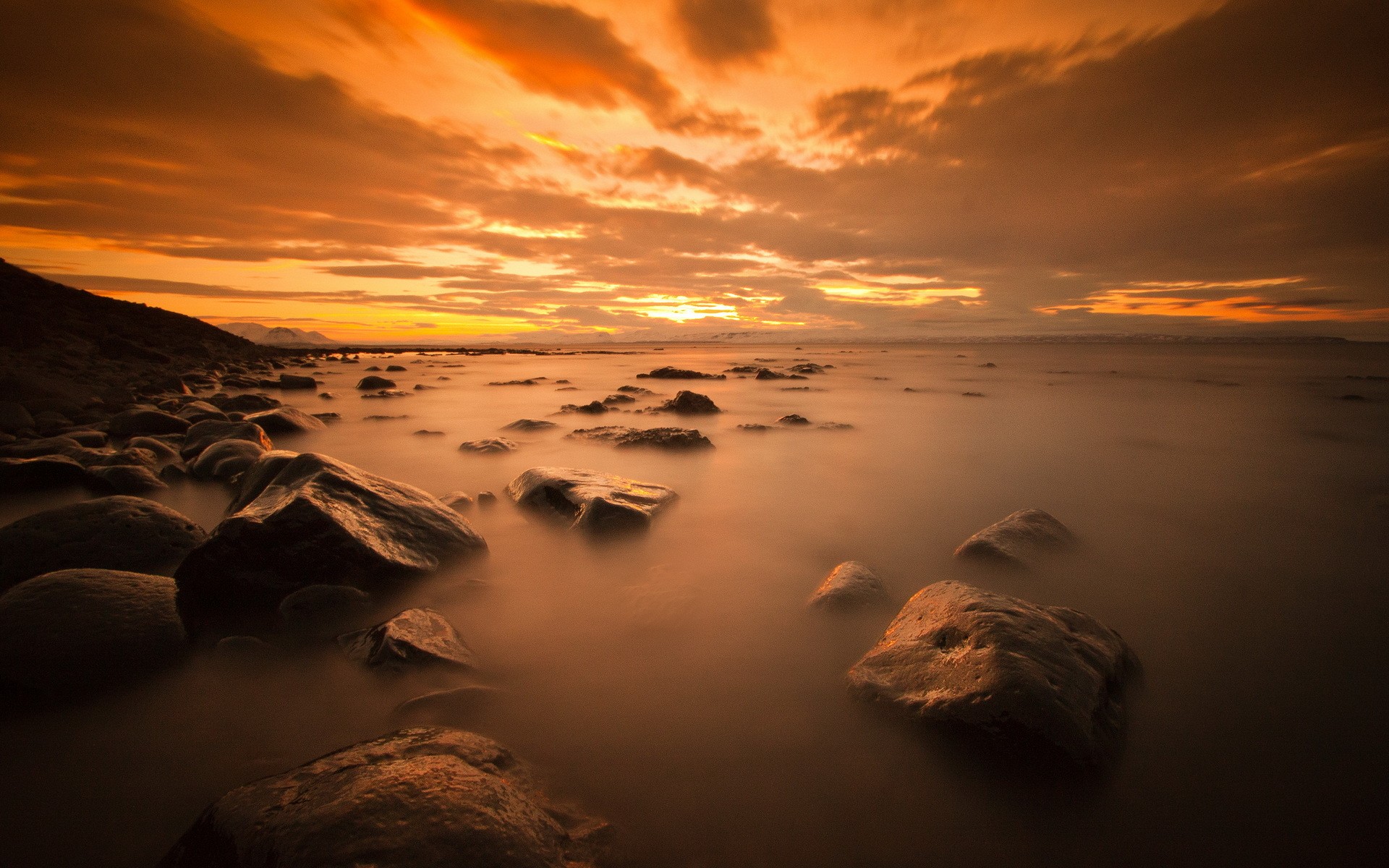 Rocky coast at sunset with orange sky HD Wallpaper