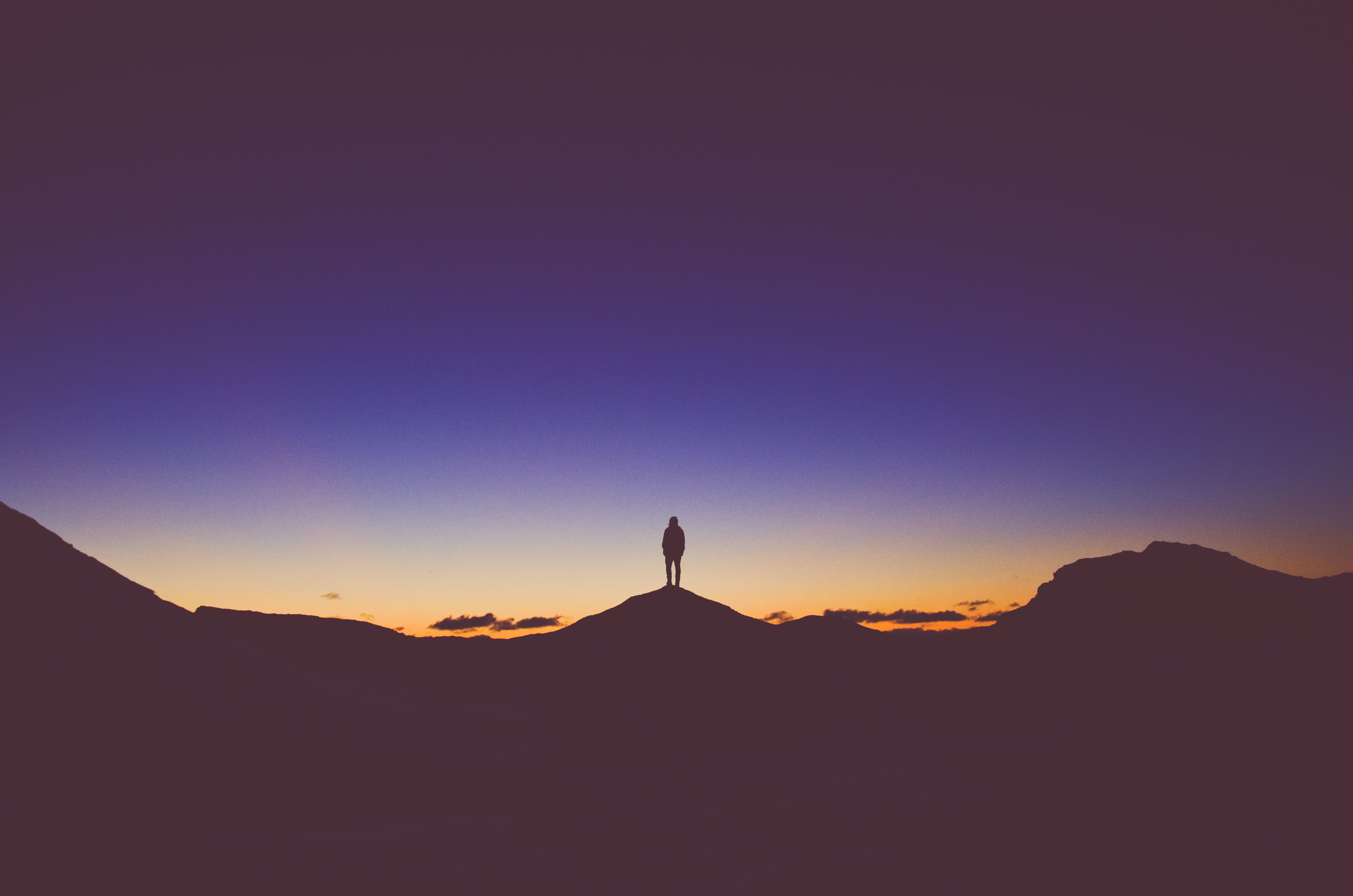 Silhouette of a person on a hilltop at sunset HD Wallpaper