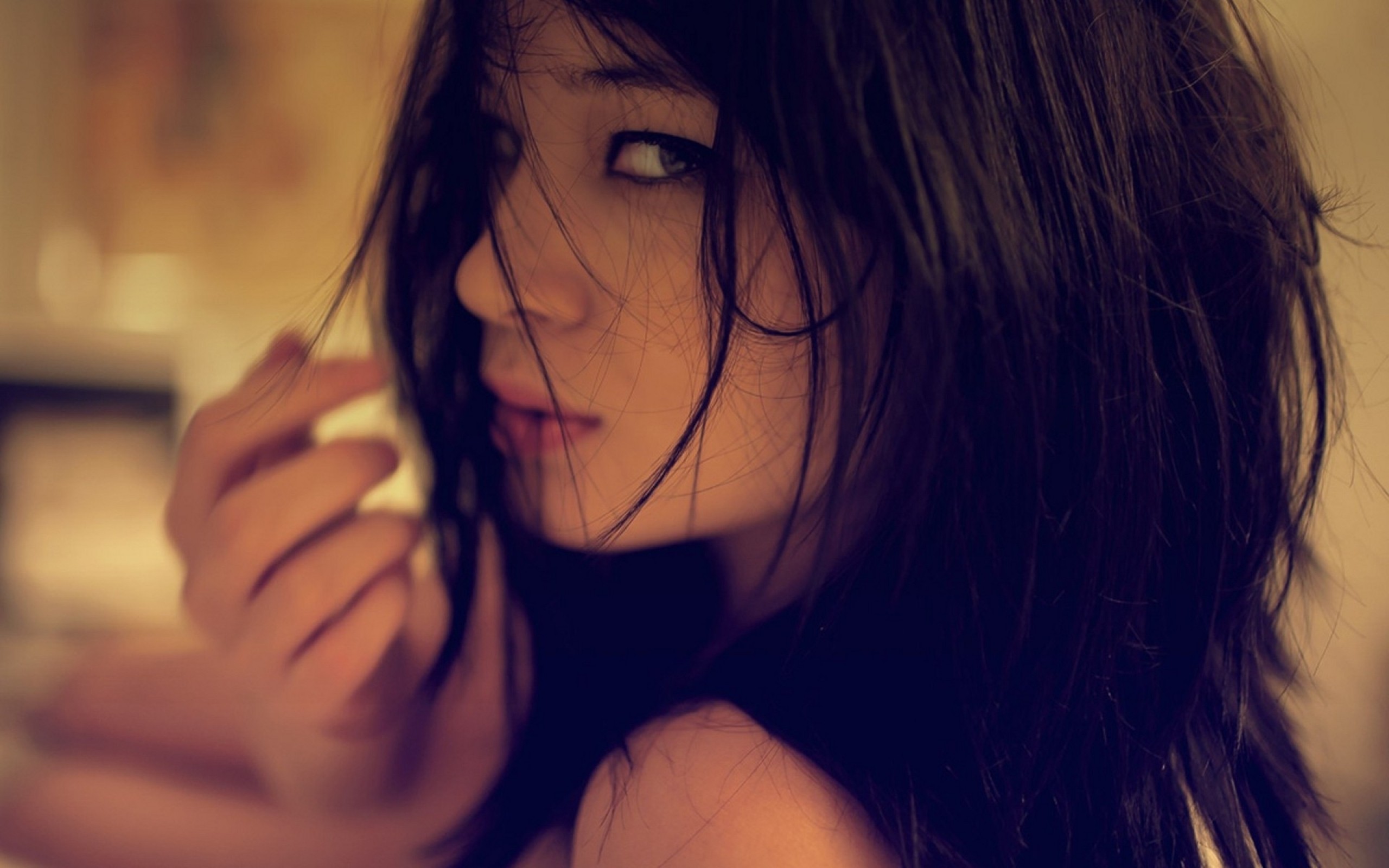 Brunette woman with dark hair looking over her shoulder HD Wallpaper