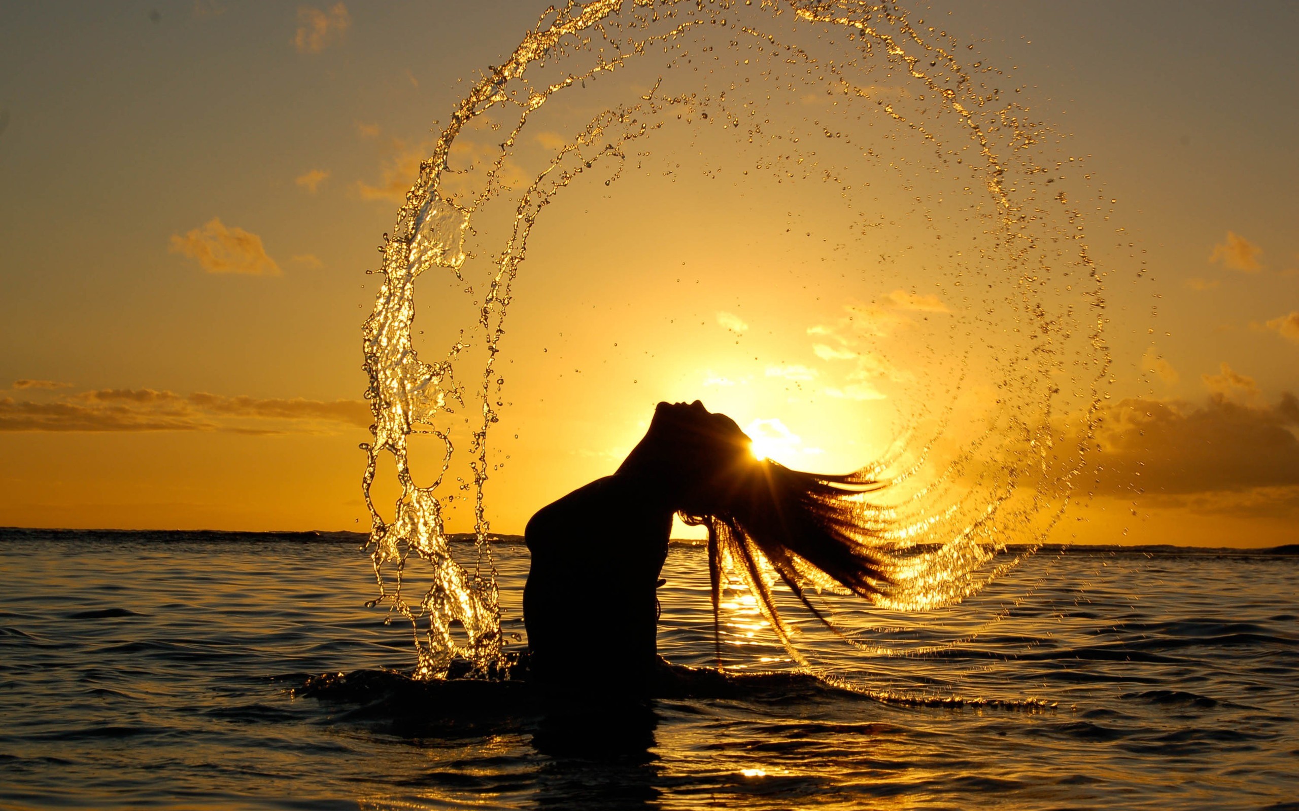 Silhouette of a woman splashing water at sunset HD Wallpaper