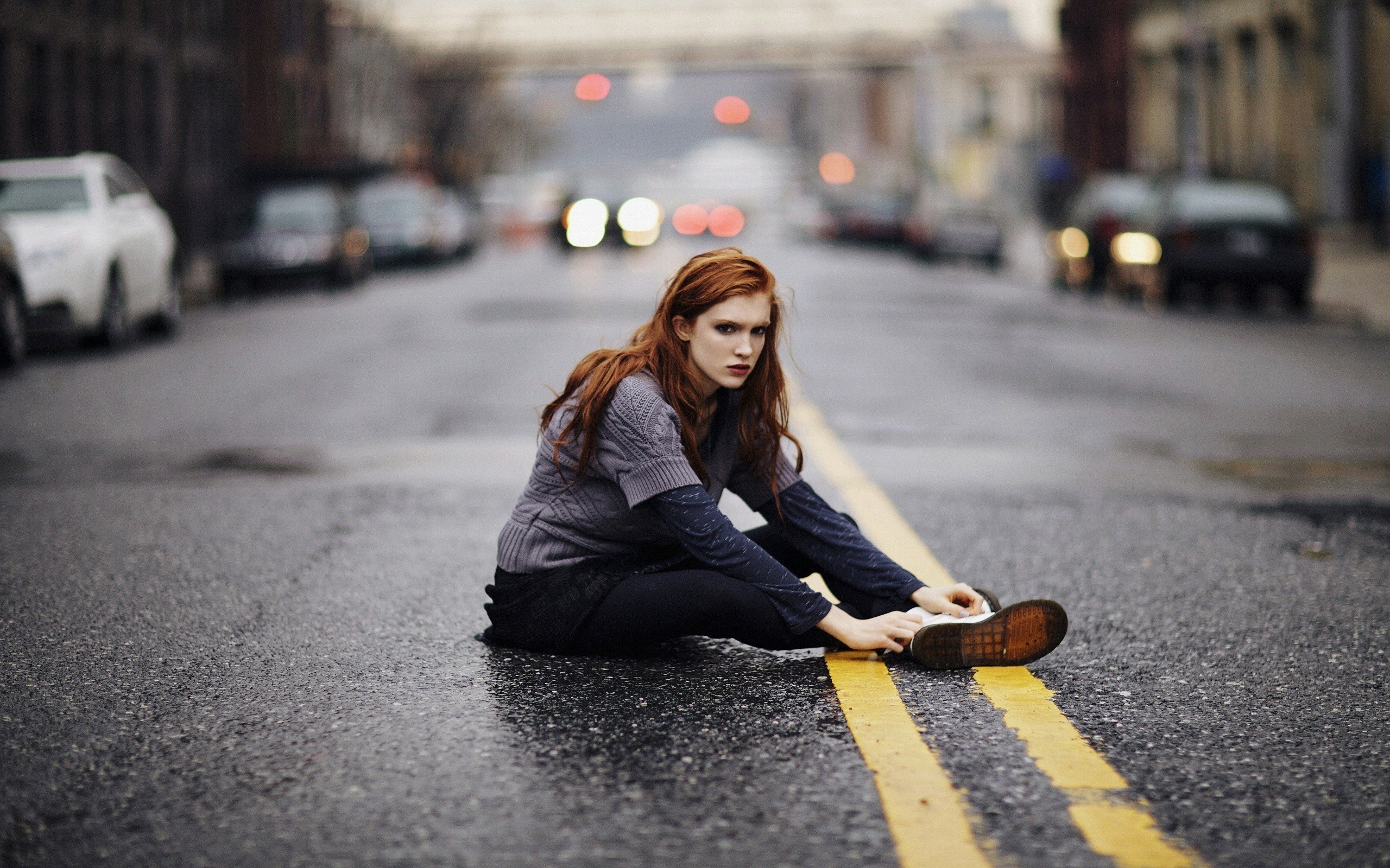 Redhead woman sitting on a city road HD Wallpaper