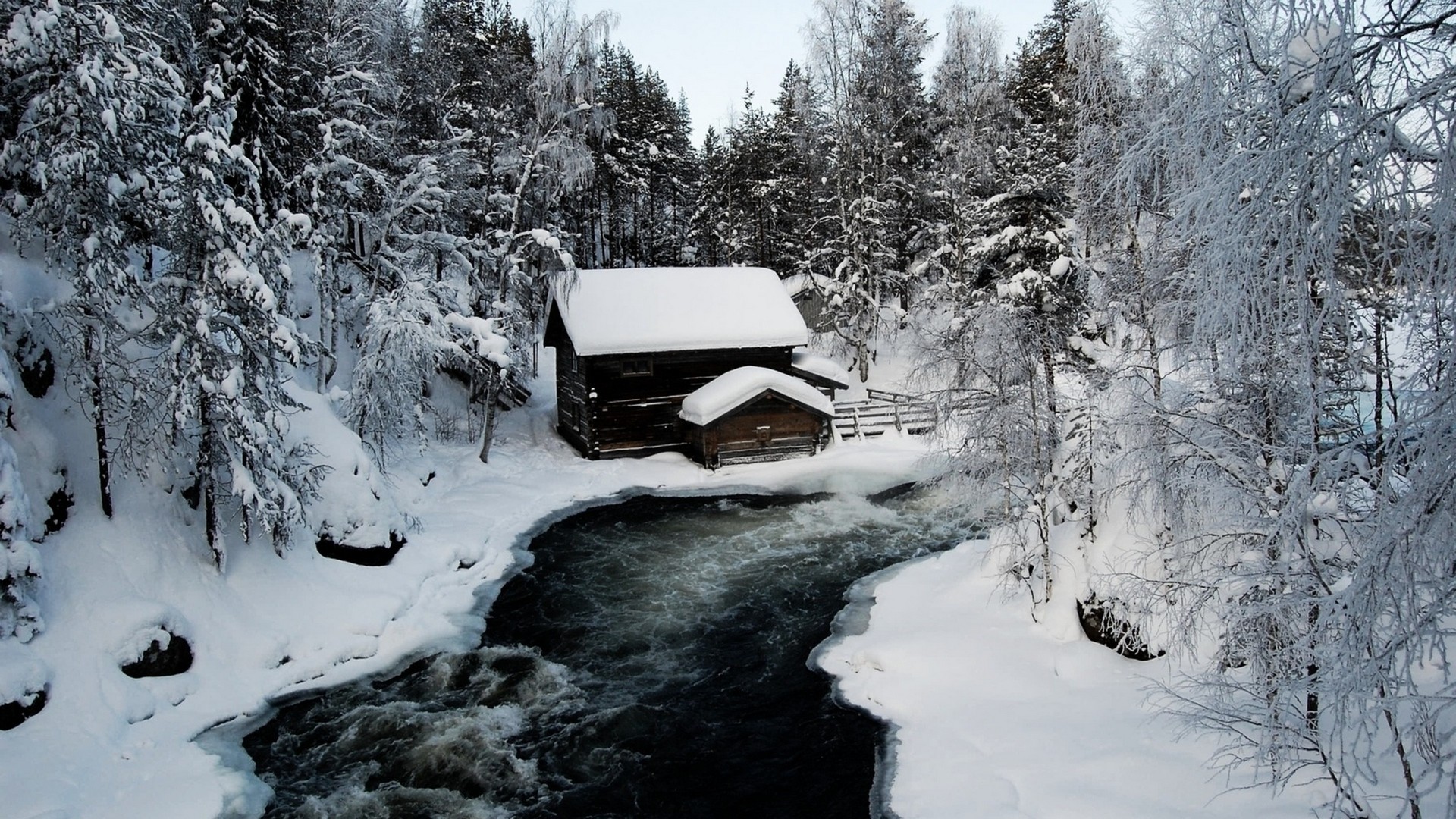 Wooden cabin by a river in a snowy forest HD Wallpaper
