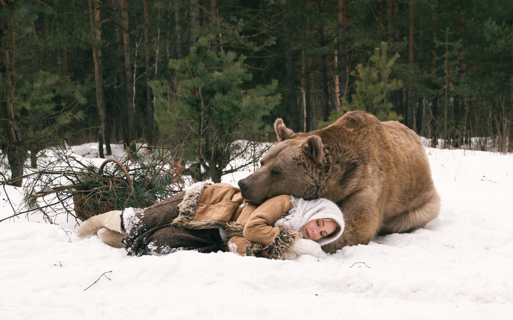 Woman sleeping with a bear in a snowy forest HD Wallpaper