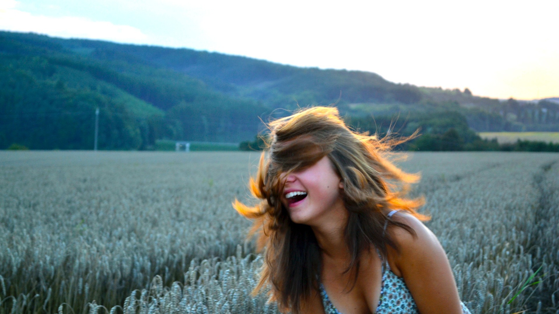 Woman laughing in a wheat field at sunset HD Wallpaper