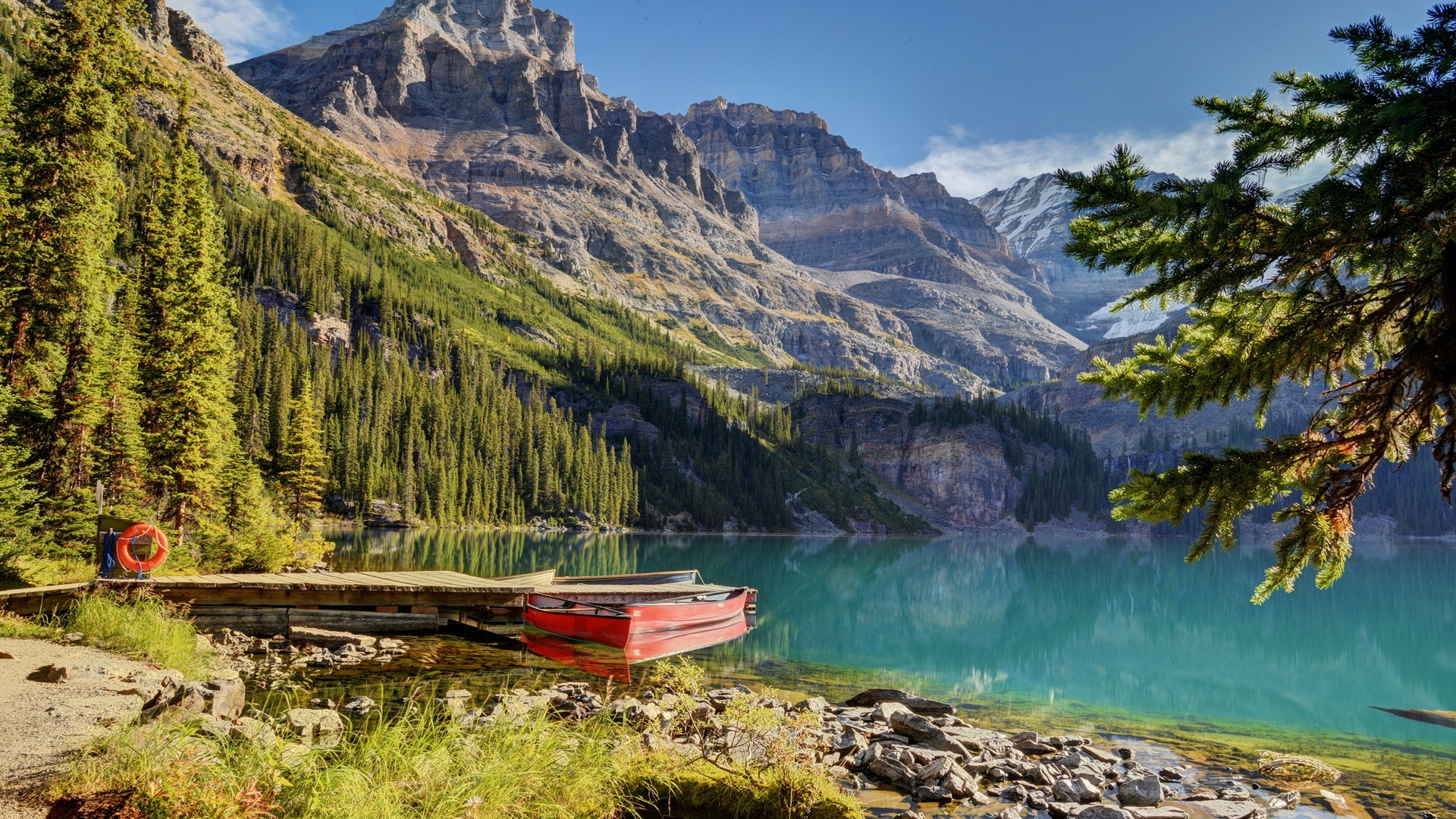 Red boat on a wooden dock by a turquoise lake and mountains HD Wallpaper