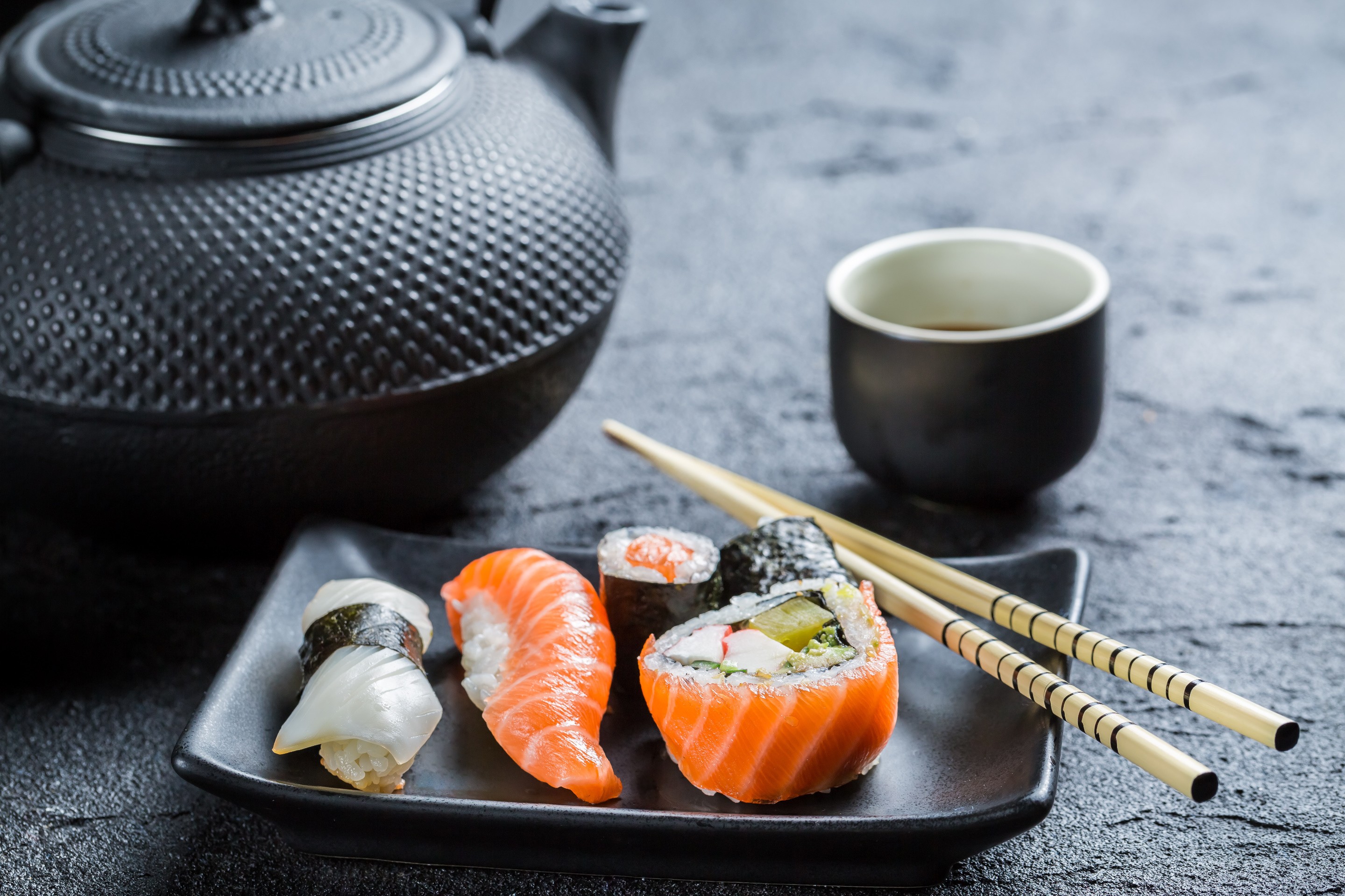 Sushi and tea set on a dark surface HD Wallpaper