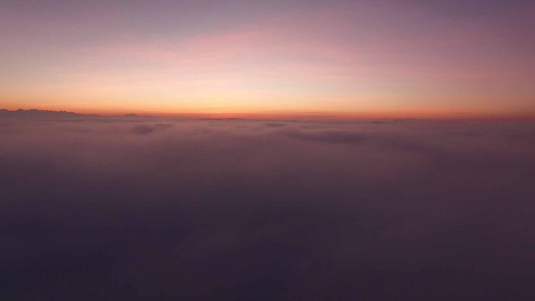 Sunset over clouds with mountain range silhouette HD Wallpaper