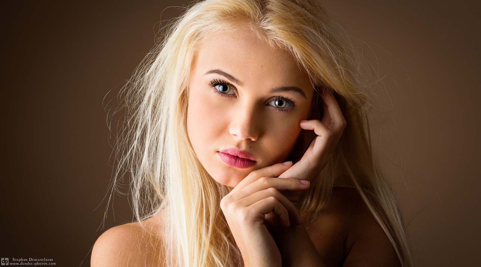 Portrait of a blonde woman with hands near face HD Wallpaper