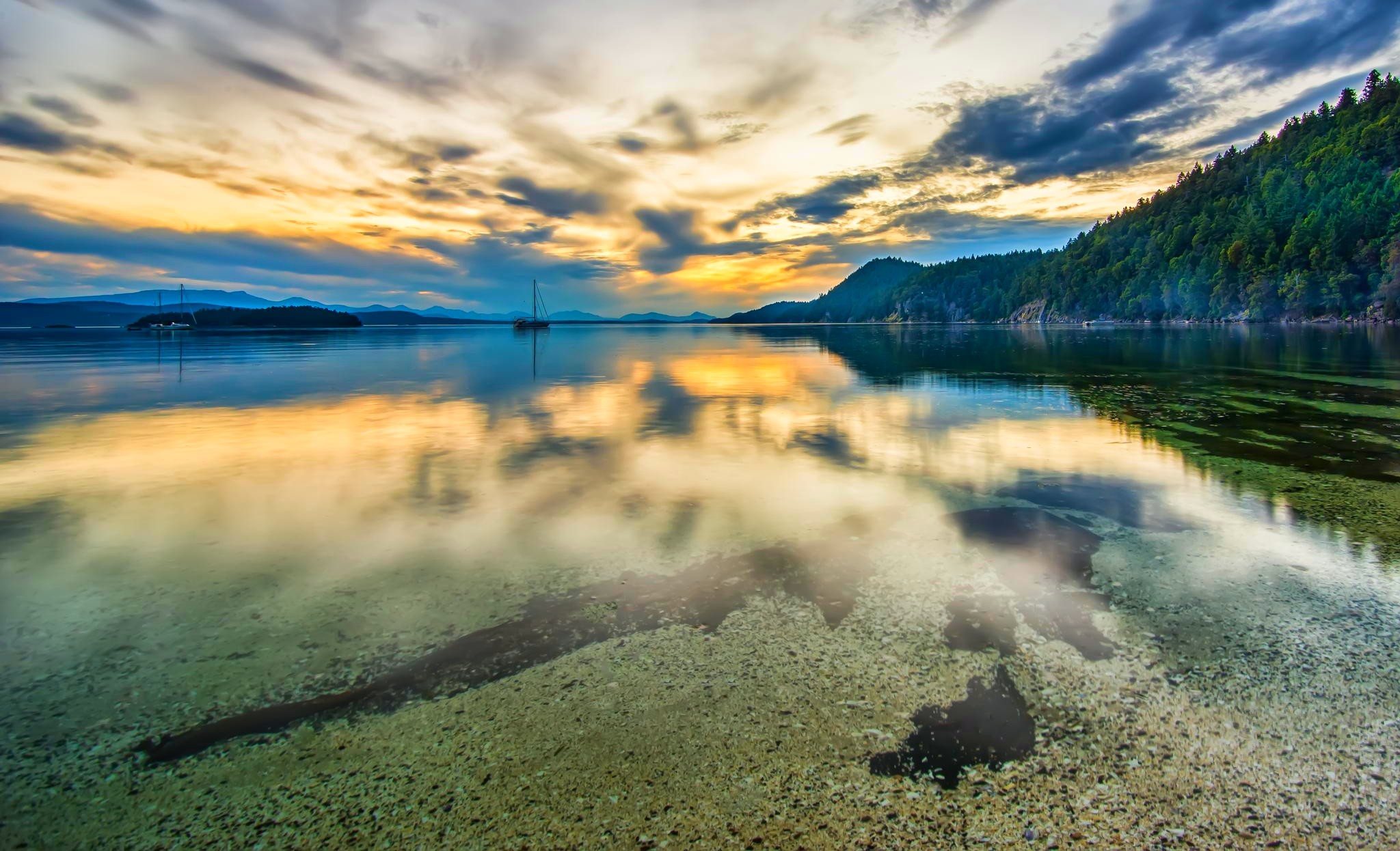 Sunset over a calm sea with a sailing ship in British Columbia HD Wallpaper