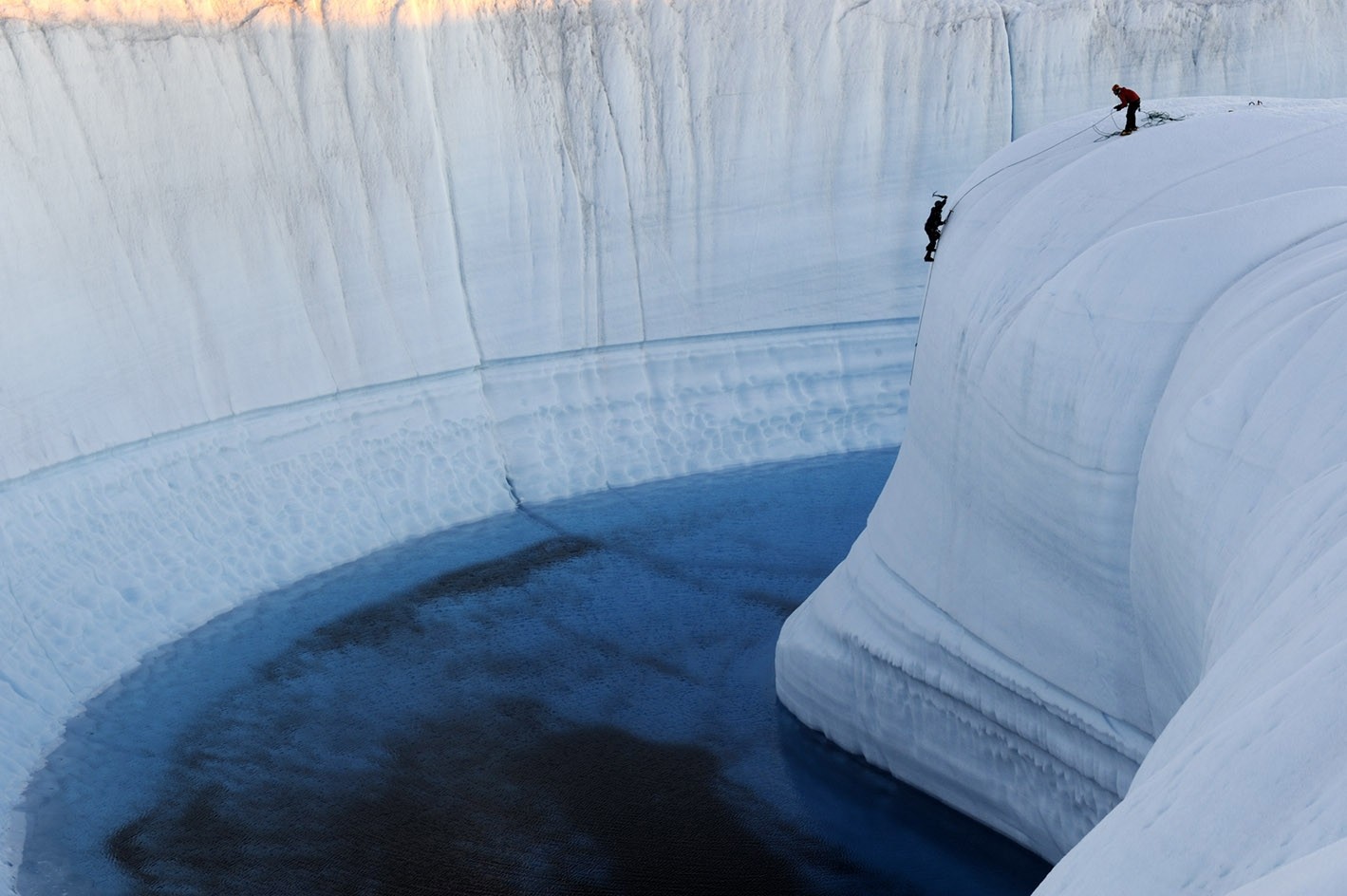 Two climbers rappelling down an icy crevasse HD Wallpaper