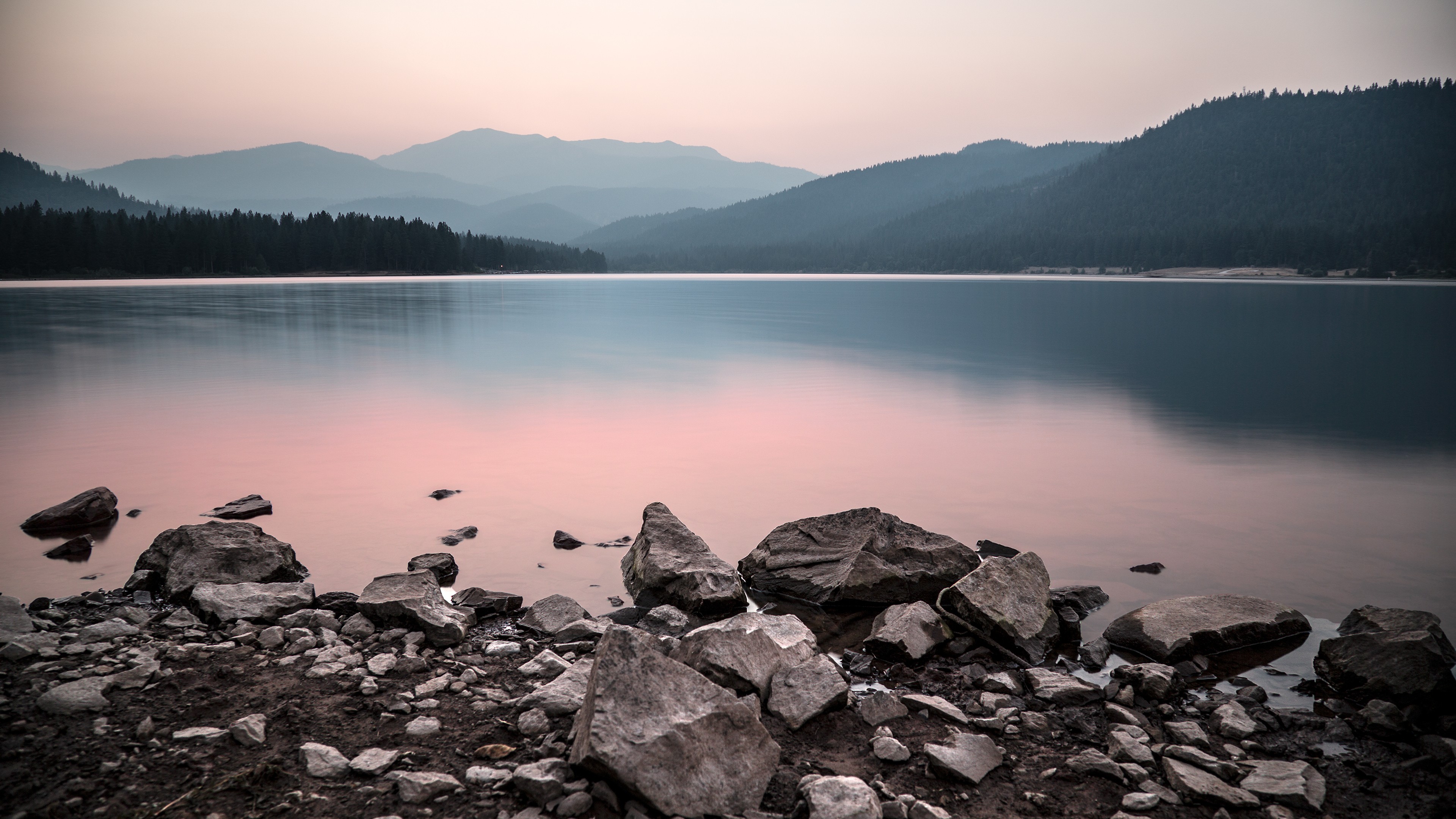 Calm lake with mountains and rocks at sunset HD Wallpaper