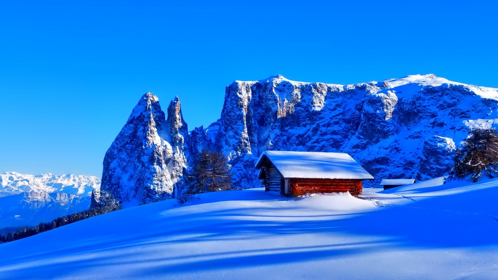 Snowy mountains with a small wooden cabin HD Wallpaper