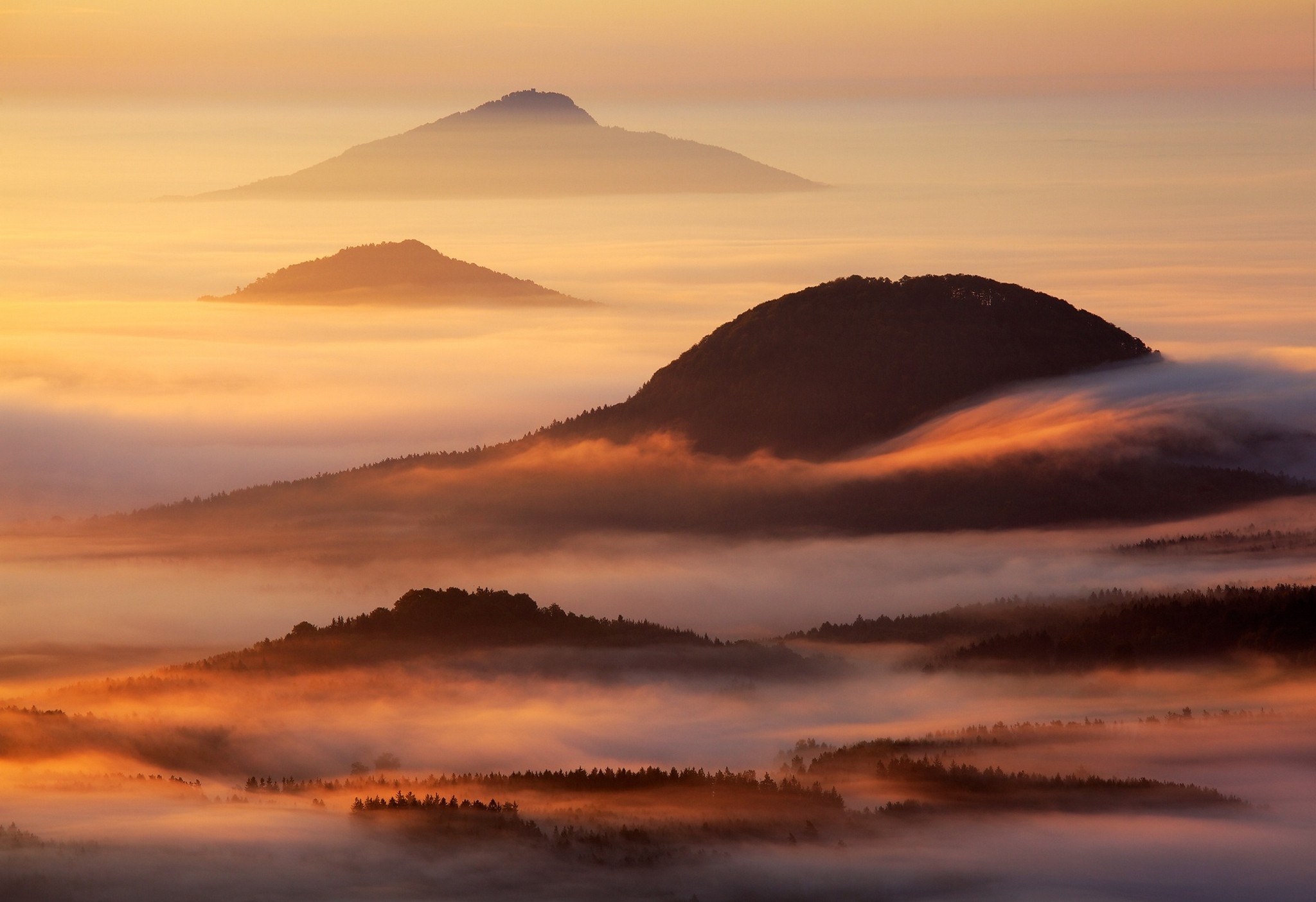 Mountains shrouded in mist at sunrise HD Wallpaper