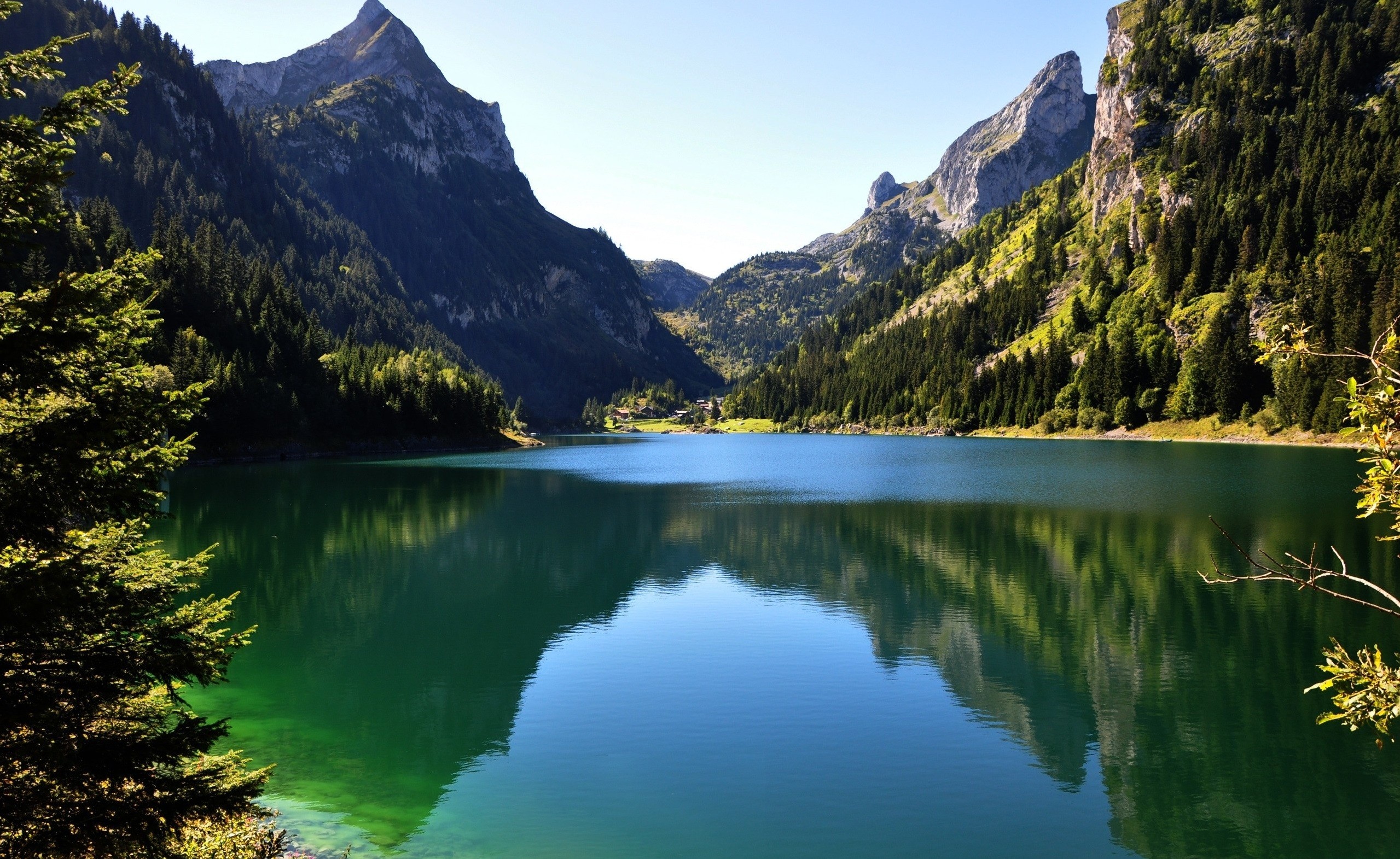 Lake reflecting mountains and trees under a clear sky HD Wallpaper