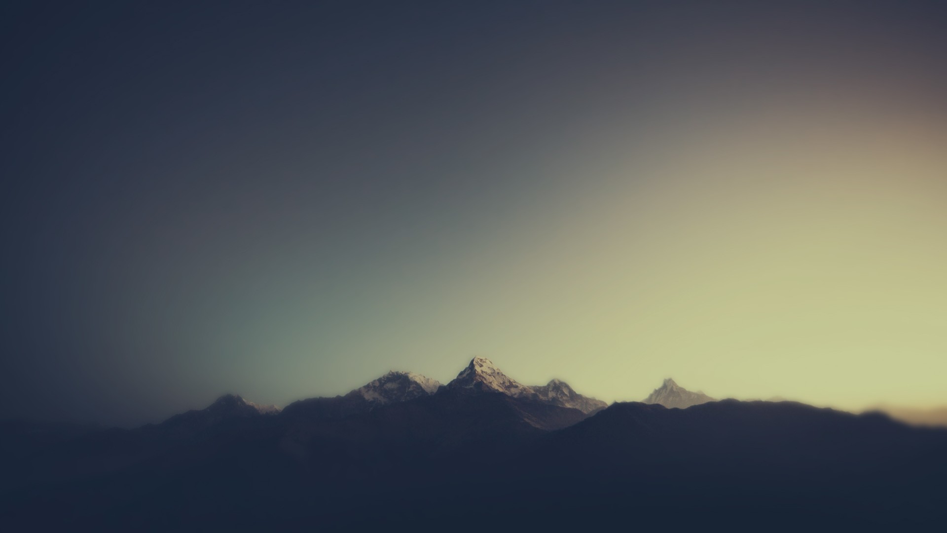 Snow-capped mountains emerge from dark clouds at sunset HD Wallpaper