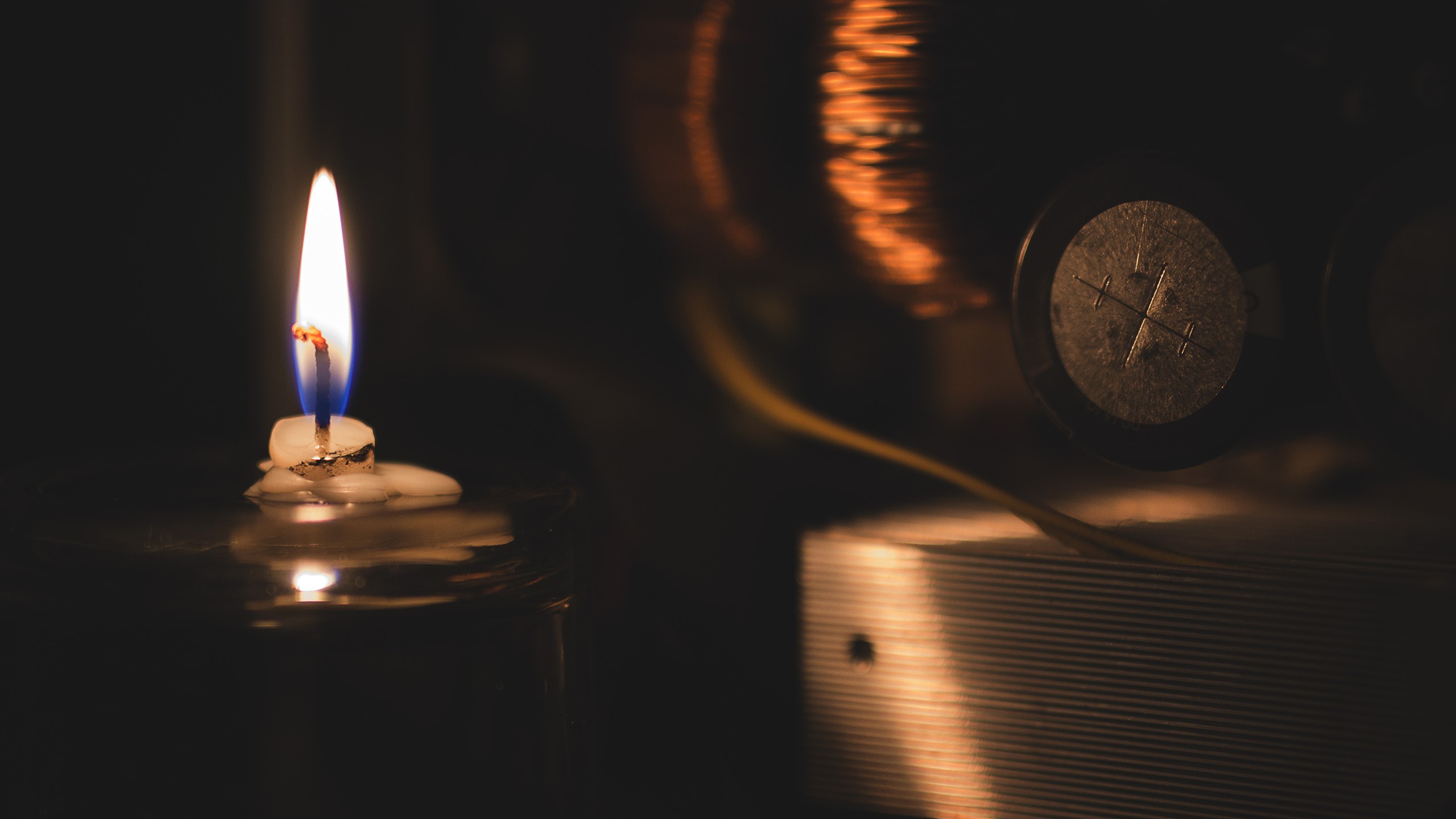 Close-up of a lit candle with melted wax HD Wallpaper