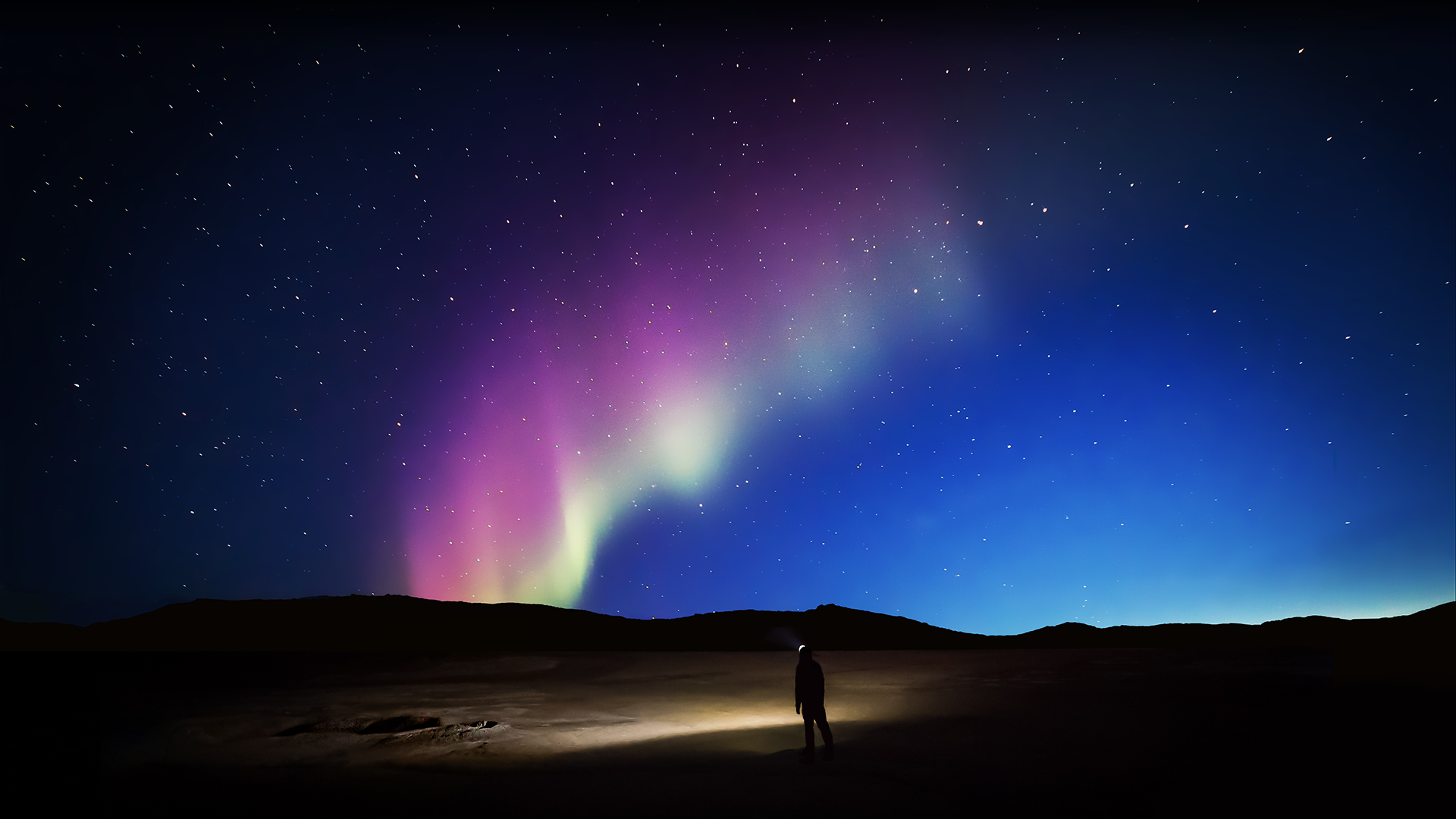 Aurora Borealis over a dark landscape with a person HD Wallpaper