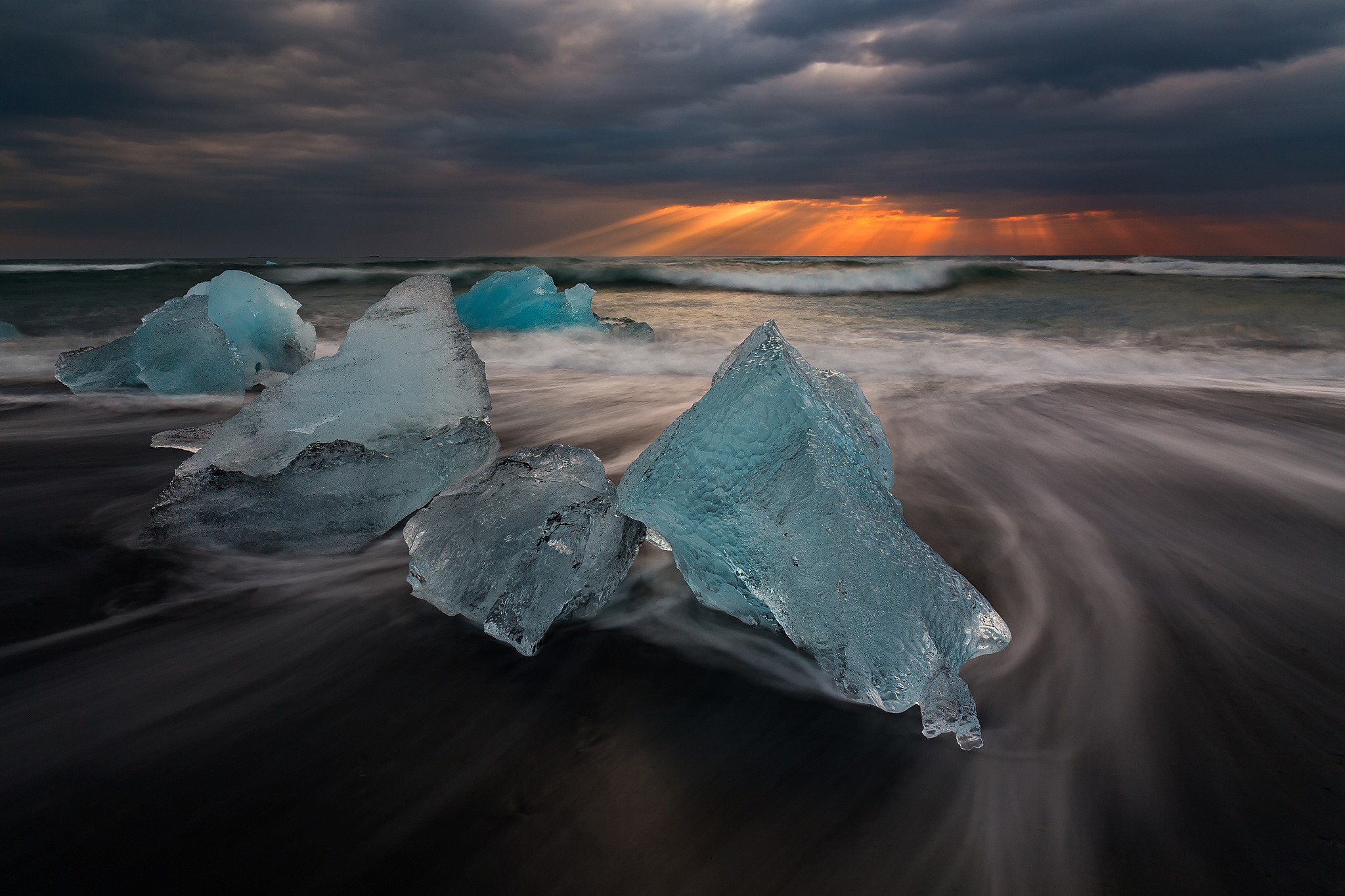Icebergs on a black sand beach in Iceland at sunset HD Wallpaper