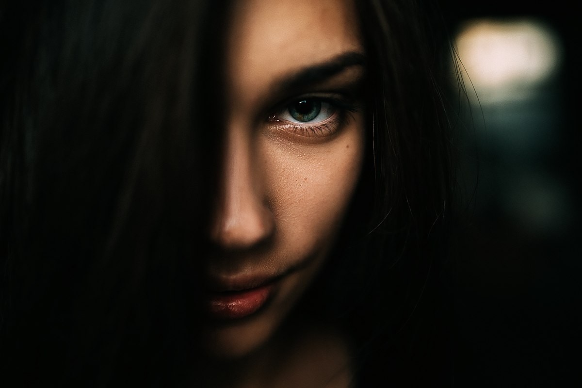 Close-up of a woman's face with dark hair HD Wallpaper
